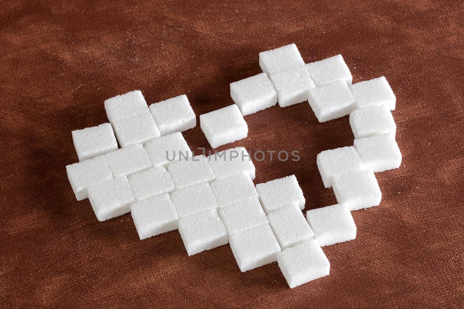 Sweet cute heart made of sugar cubes on brown natural background texture, love,sweets,candy,sugar,food concept modern design with hole