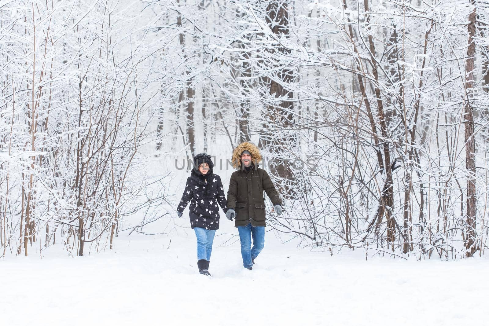 Young couple in love walks in the snowy forest. Active winter holidays. by Satura86