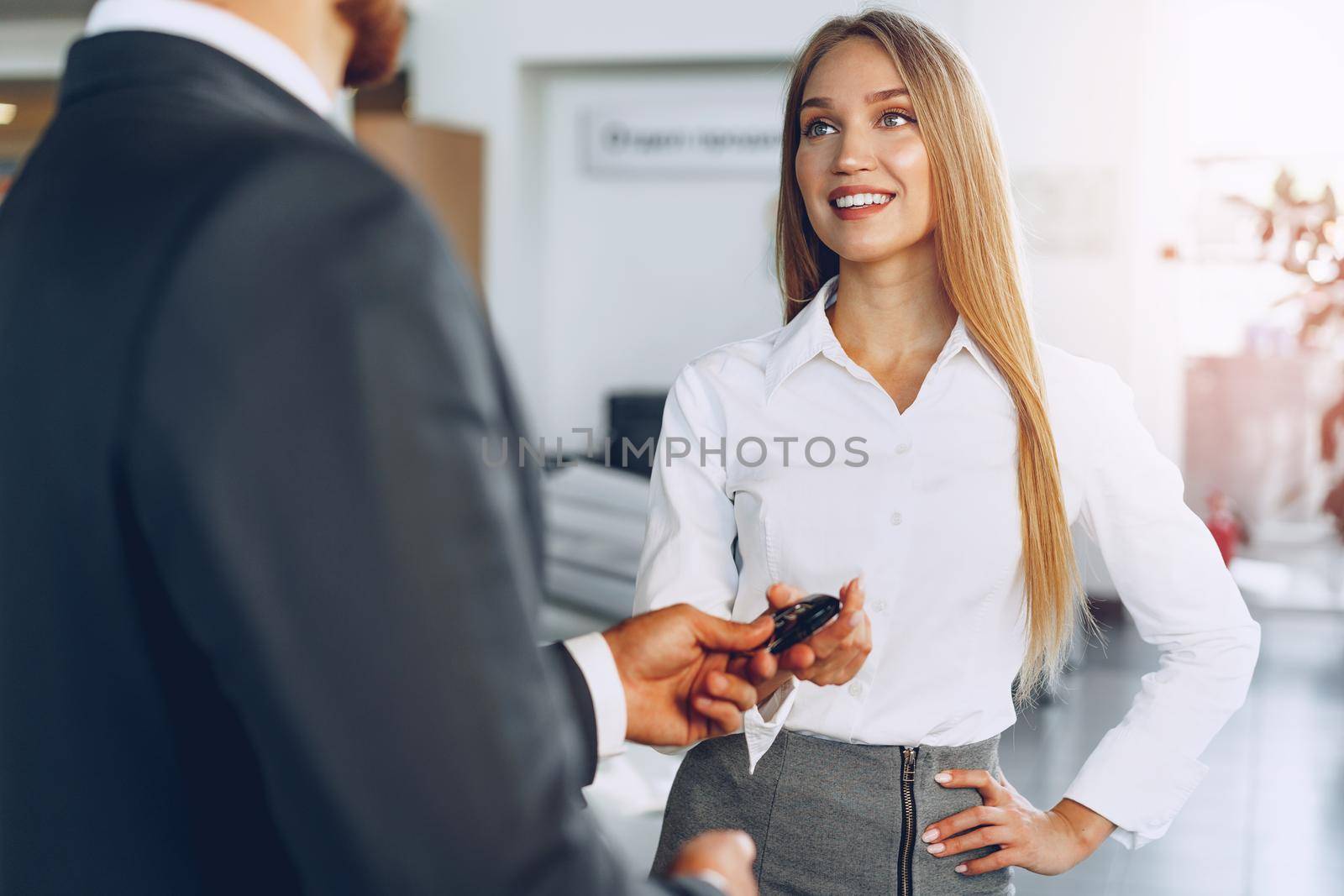 Young attractive woman buying a new car in car salon by Fabrikasimf