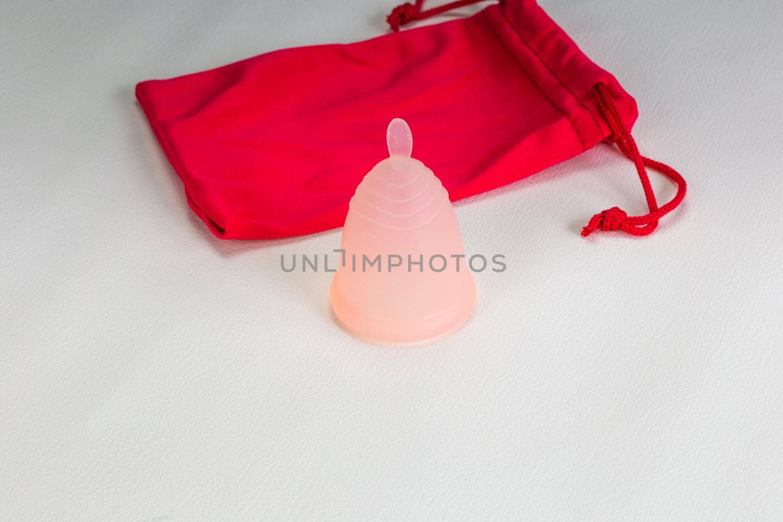 Menstrual cup on white background. Eco friendly alternative for Women period products with copy space and pink pounch