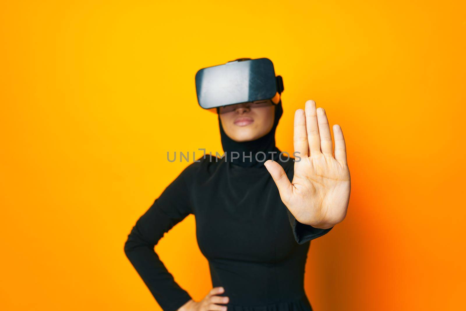 cheerful woman in black hijab VR glasses emotions studio lifestyle. High quality photo