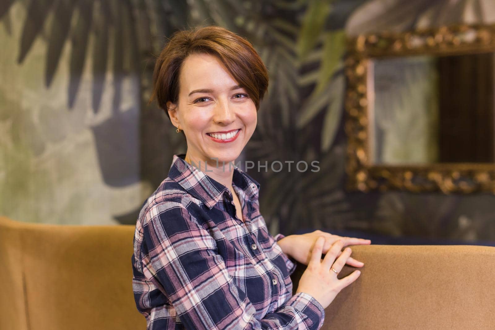 Portrait of confident woman smiling in cafe by Satura86