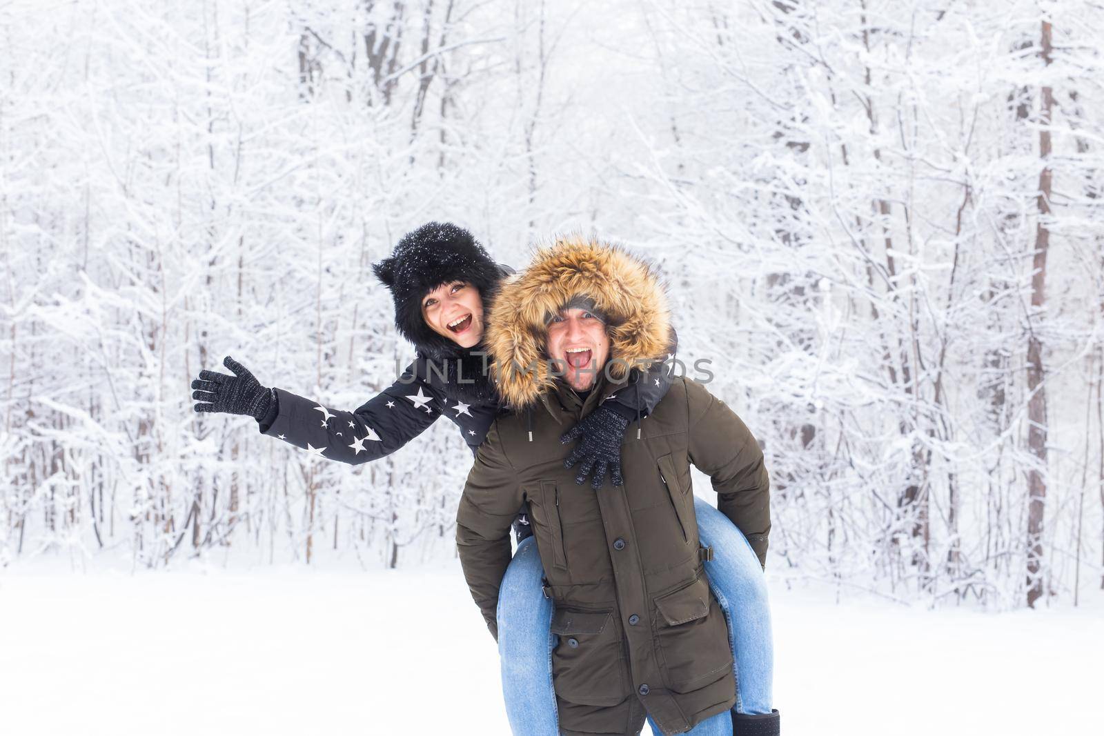 Portrait of happy young couple in winter park with their friend behind by Satura86