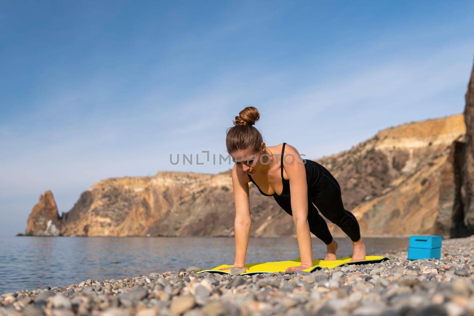 Group of young womans fitness instructor in Sportswear Leggings and Tops, stretching in the gym before pilates, on a yoga mat near the large window on a sunny day, female fitness yoga routine concept.