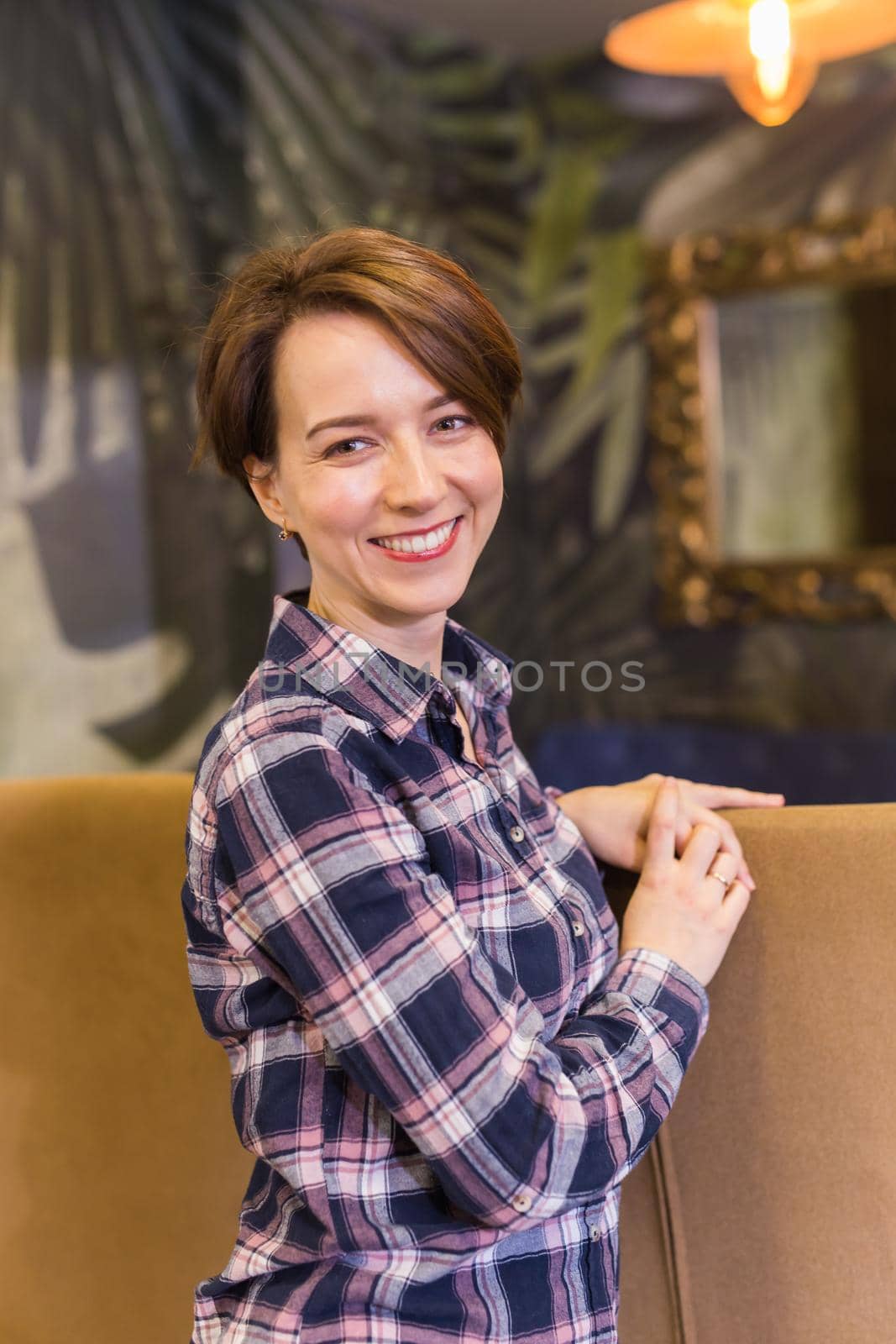 Portrait of confident woman smiling in cafe.