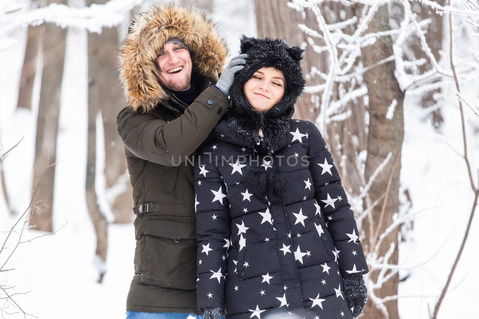 Young couple walking in a snowy park. Winter season