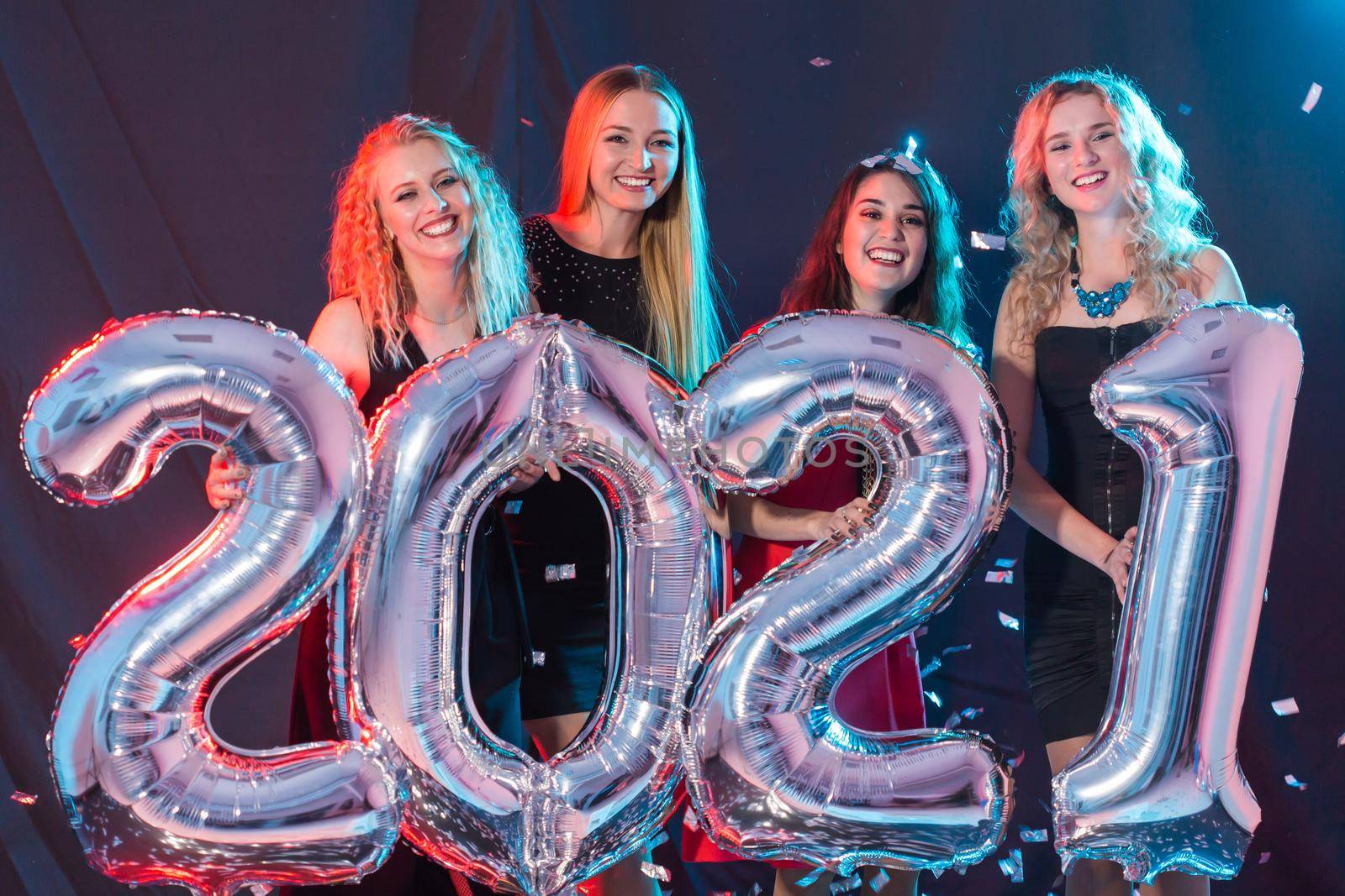 Party and new year holidays concept - cheerful young women celebrating new years eve 2021