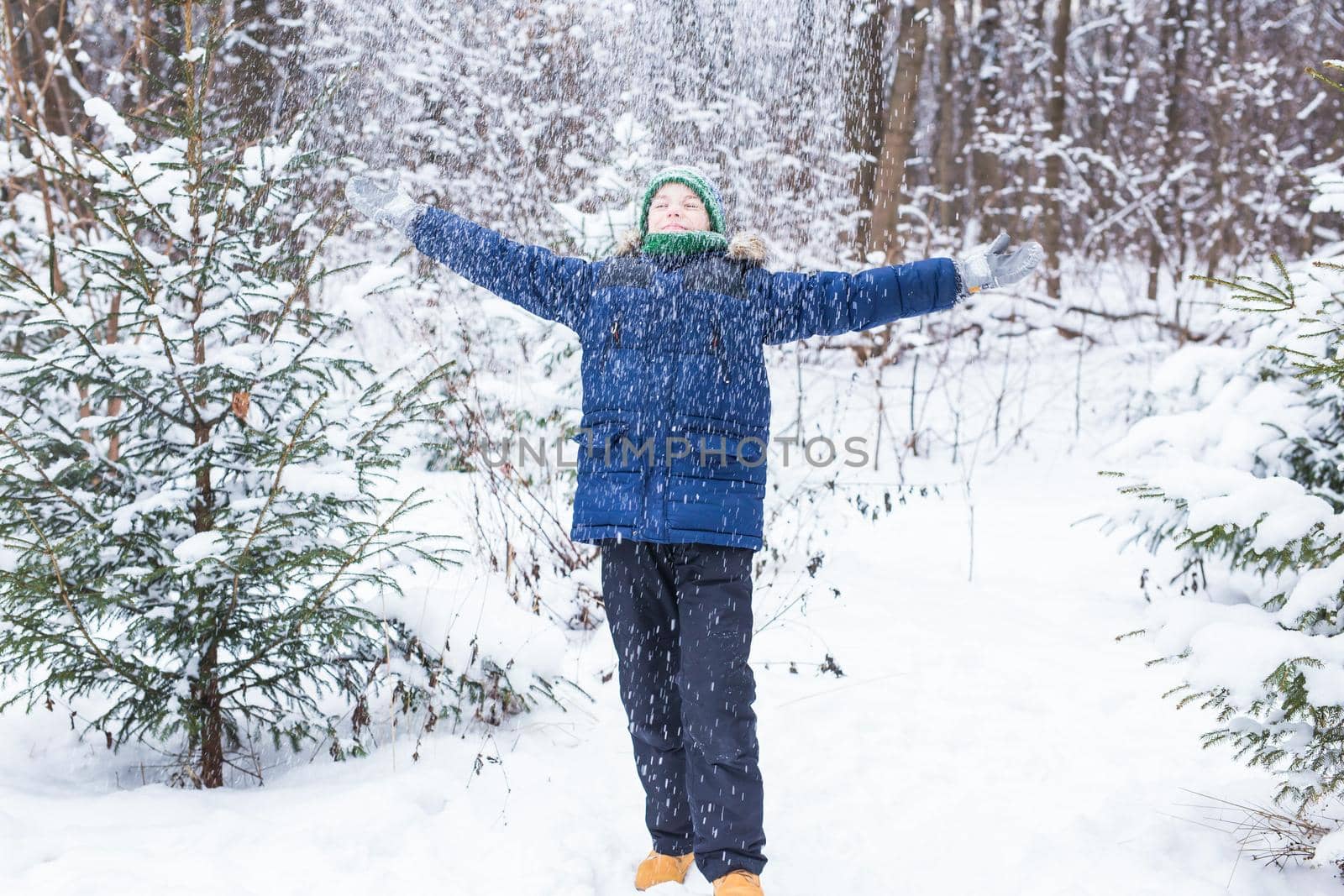 Happy boy throwing snow. Child, season and winter concept. by Satura86