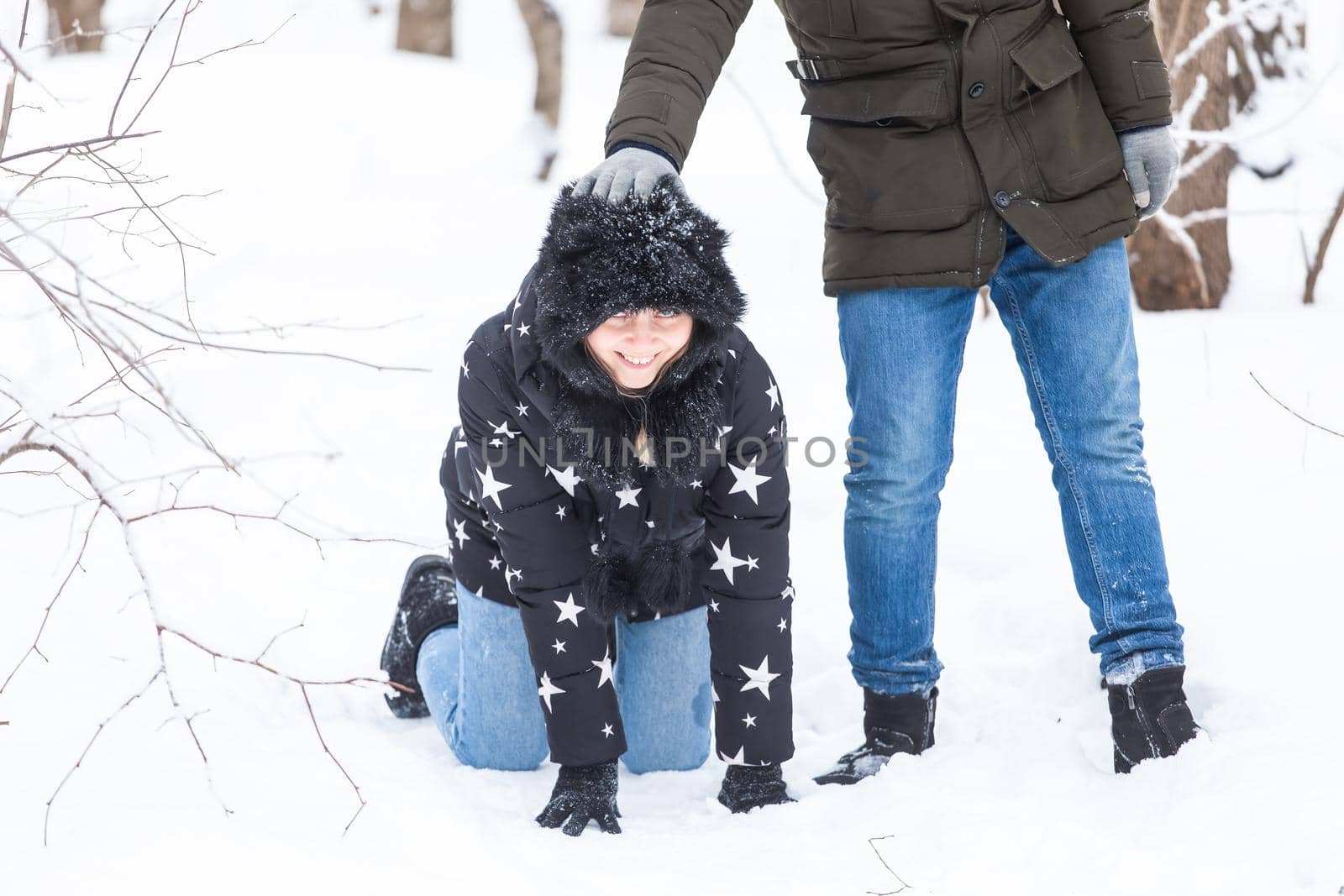 Fun, season and leisure concept - love couple plays winter wood on snow.