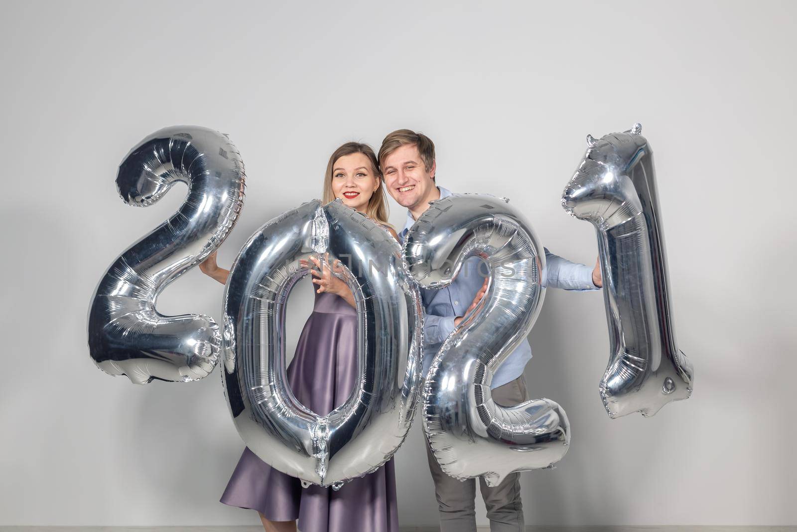 Party, people and new year holidays concept - woman and man celebrating new years eve 2021.