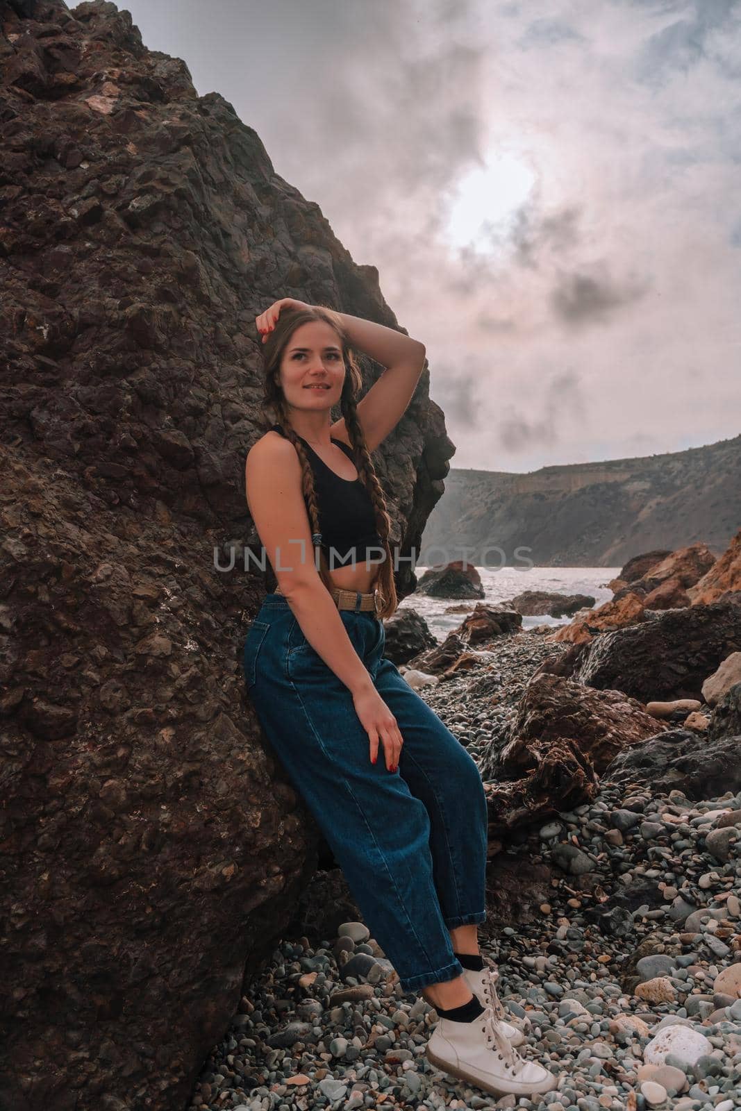 Selective focus. Happy carefree sensual woman with long hair in black swimwear posing at sunset beach. Silhouette of young beautiful playful positive woman outdoor. Summer vacation and trip concept by panophotograph