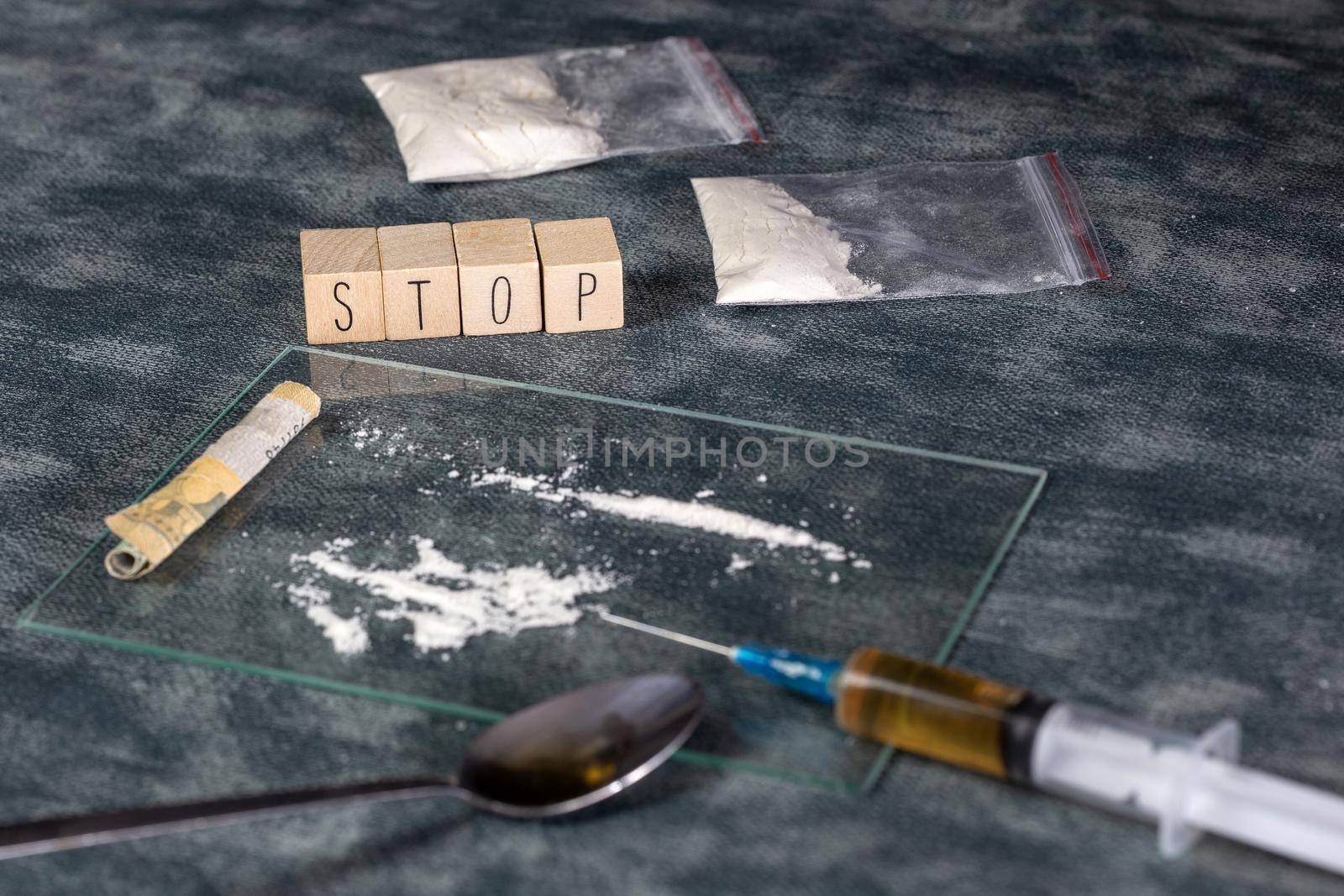 Drugs addiction, white powder line,cocaine,speed or other drugs and syringe with Heroin and the text STOP. Junk,Addiction,drug concept background help