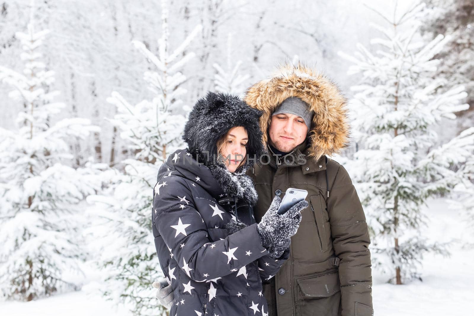 Season and relationship concept - Funny couple taking selfie in the winter time by Satura86