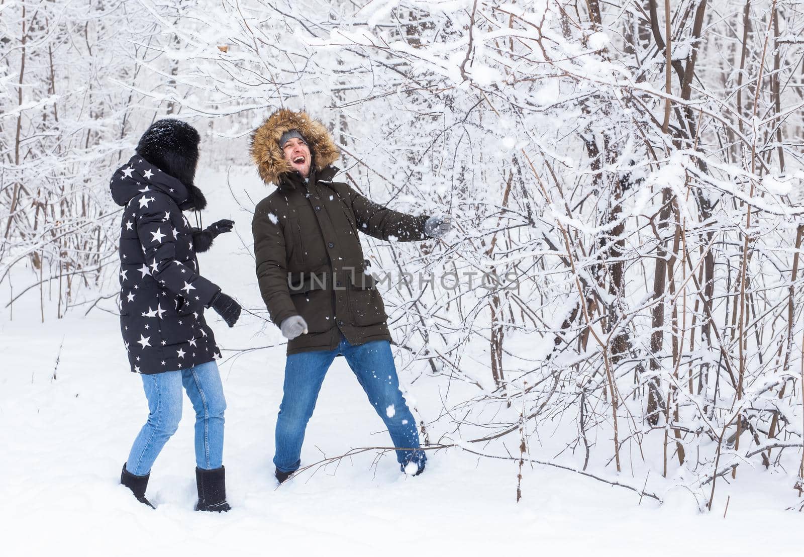 Young couple in love walks in the snowy forest. Active winter holidays