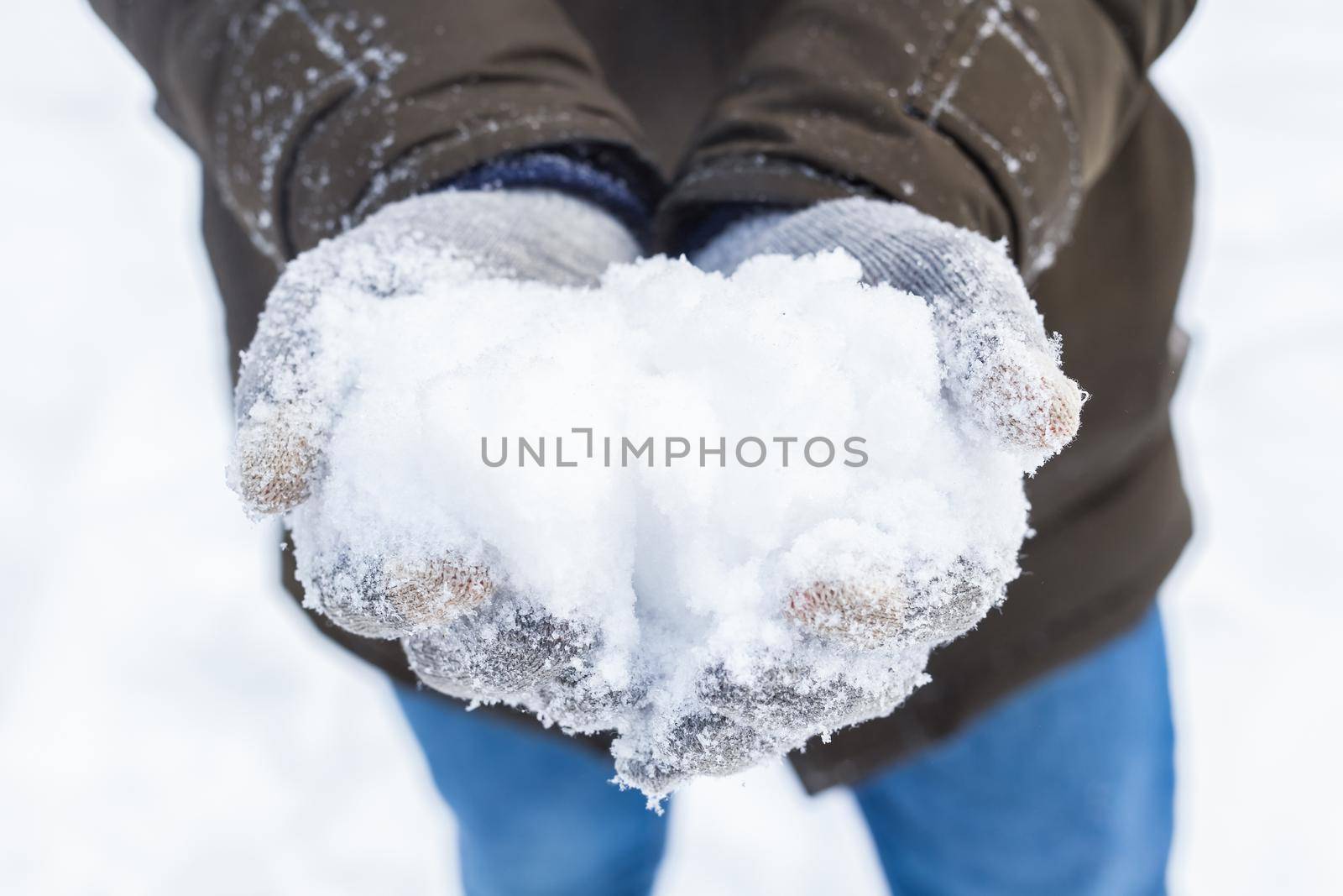 Winter and people concept - close up of man holding snow outdoors by Satura86
