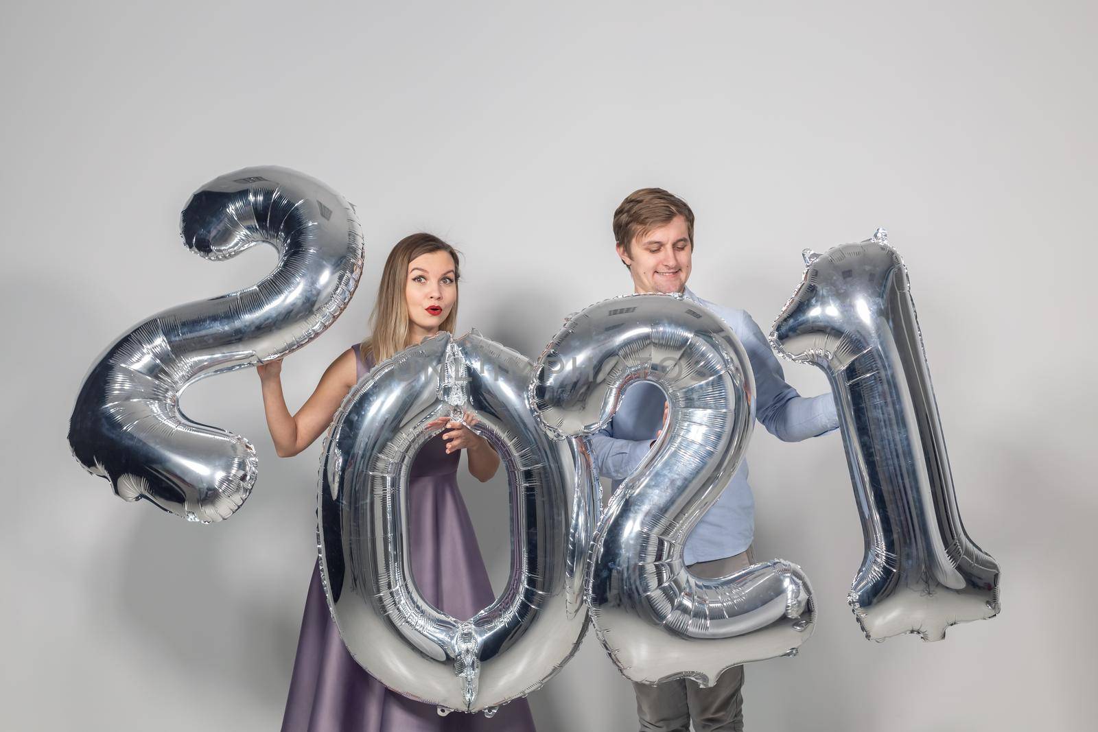 Party, people and new year holidays concept - woman and man celebrating new years eve 2021.