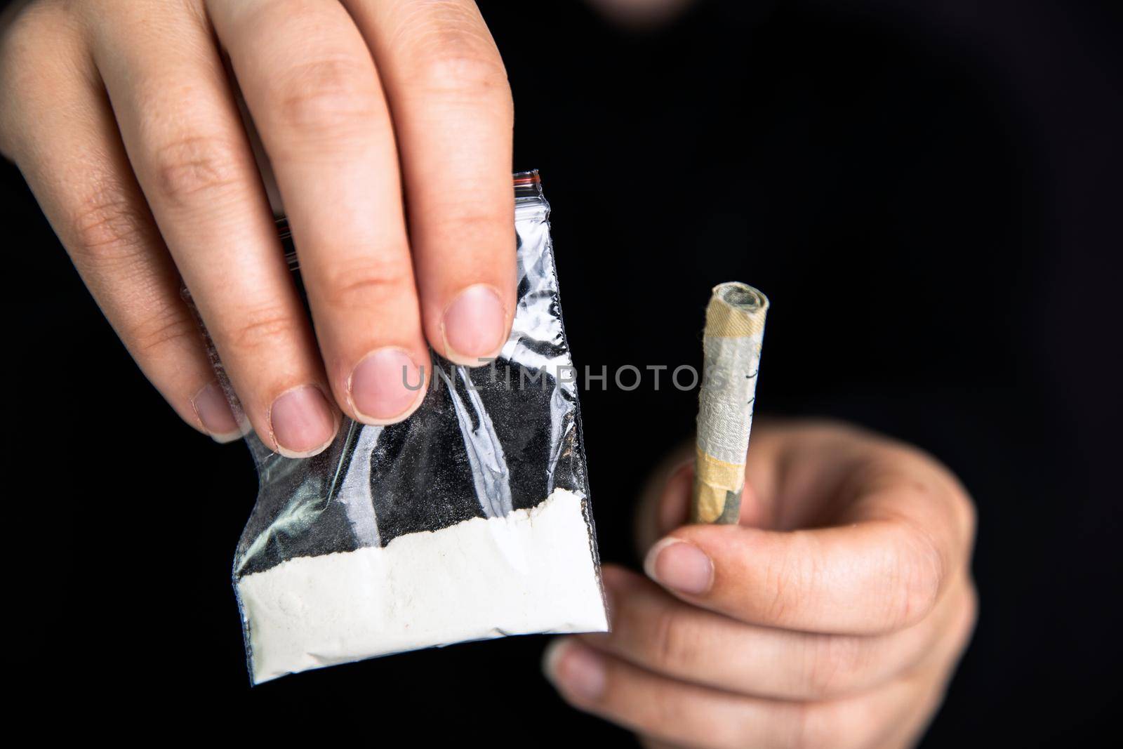 Drug dealer Giving drugs in a plastic bag, cocaine,heroin,speed or other drugs on dark black background, addiction,drugs,junky,criminal concept copy space