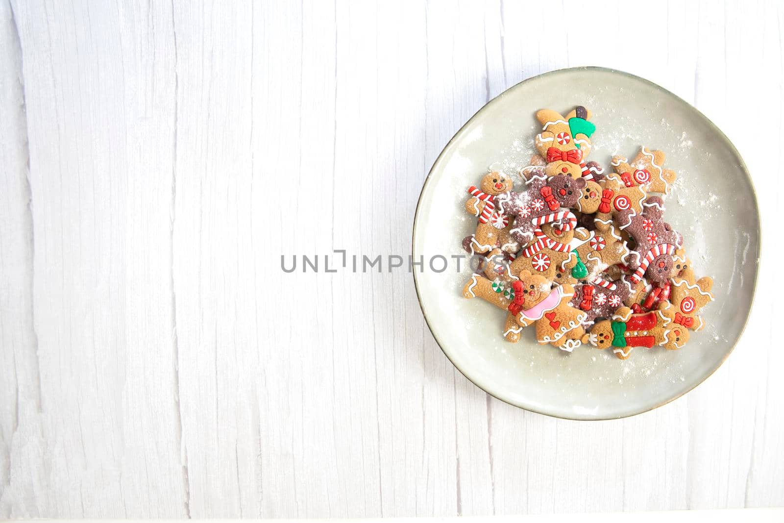 Christmas cookies,gingerbread man cookies with powdered sugar on natural plate, white wooden background texture,homemade top view copy space