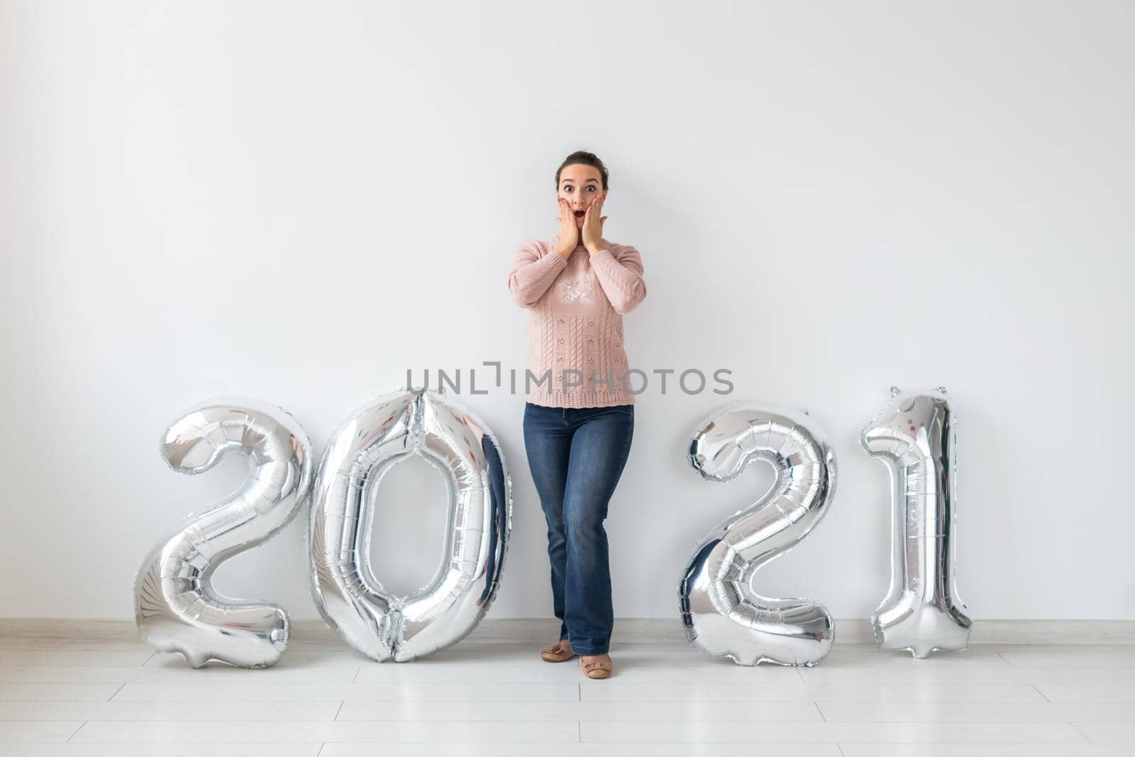 New Year celebration and party concept - Happy young woman with sparklers near silver 2021 balloons on white background. by Satura86