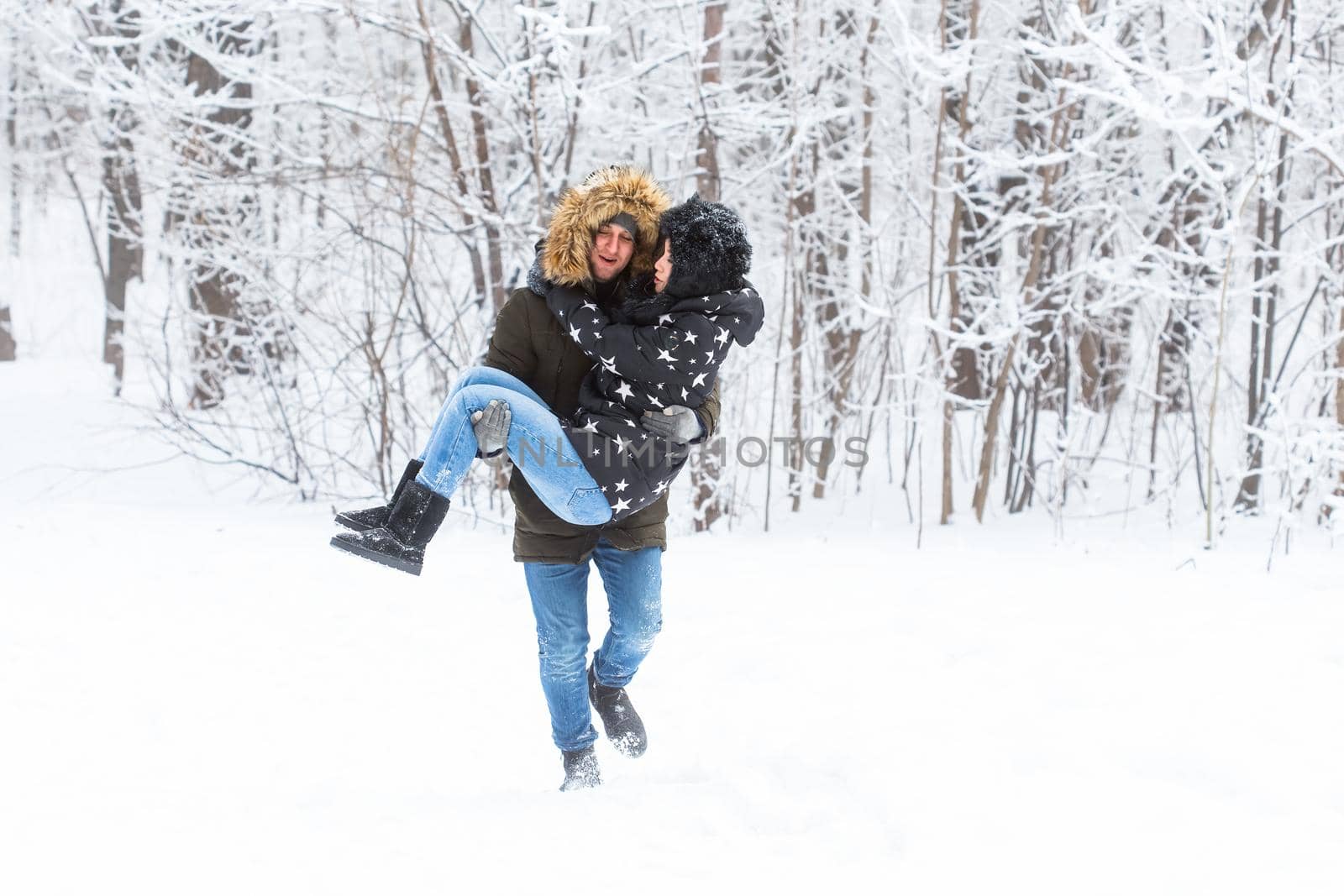 Happy loving couple having fun outdoors in snow park. Winter vacation.