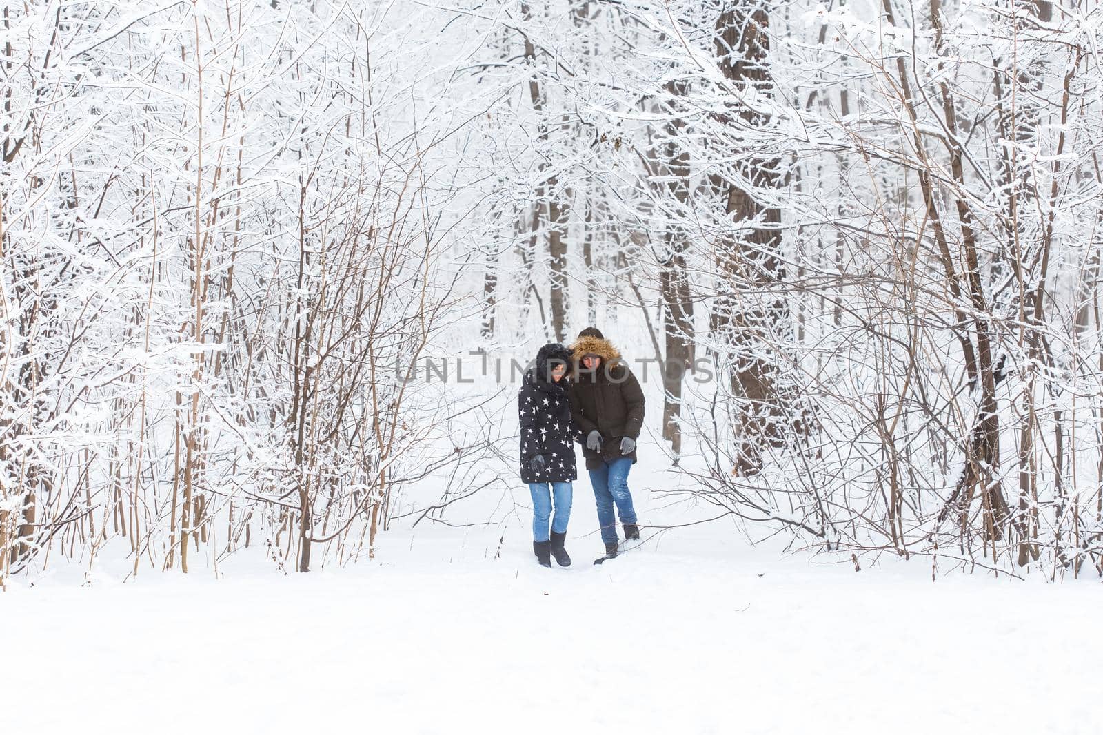 Young couple in love walks in the snowy forest. Active winter holidays. by Satura86