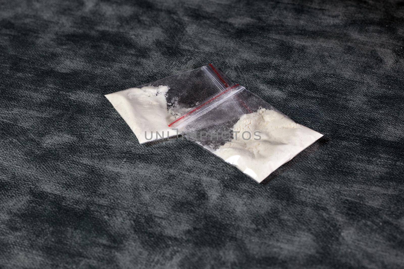 Transparent plastic bags with white powder, cocaine,speed or other drugs on gray background with copy space, dealing,drug,junky,addiction concept illegal