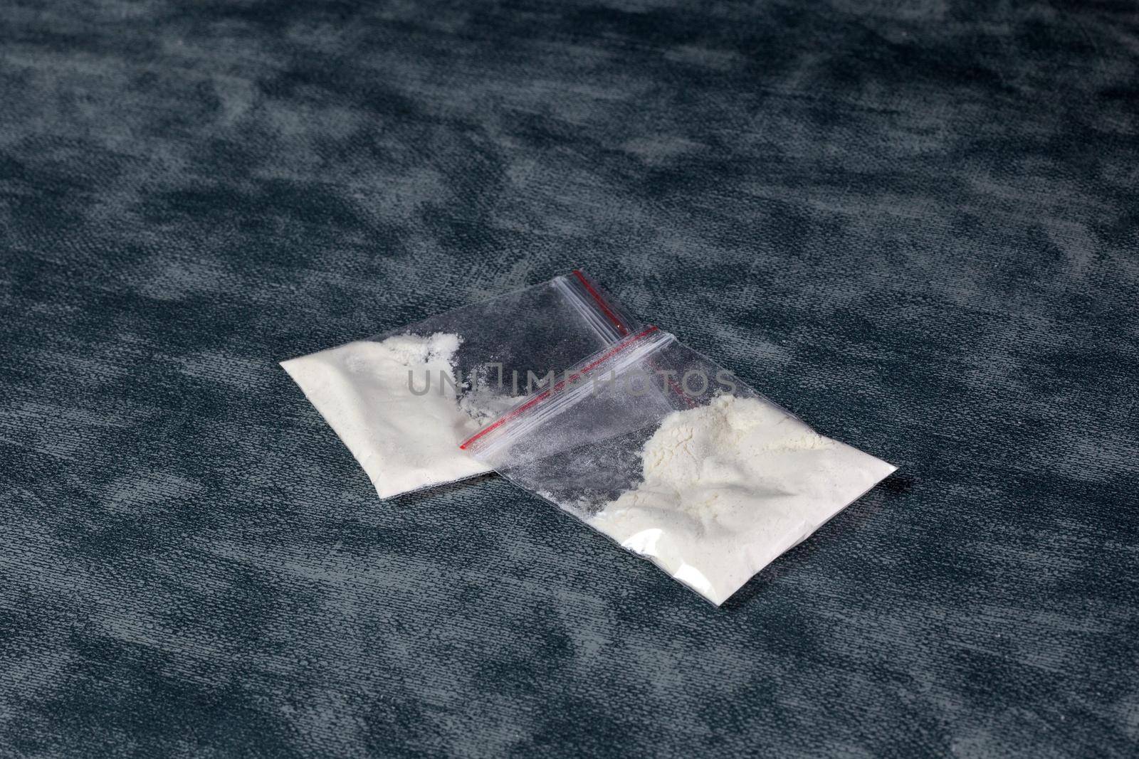 Transparent plastic bags with white powder, cocaine,speed or other drugs on gray background with copy space, dealing,drug,junky,addiction concept illegal