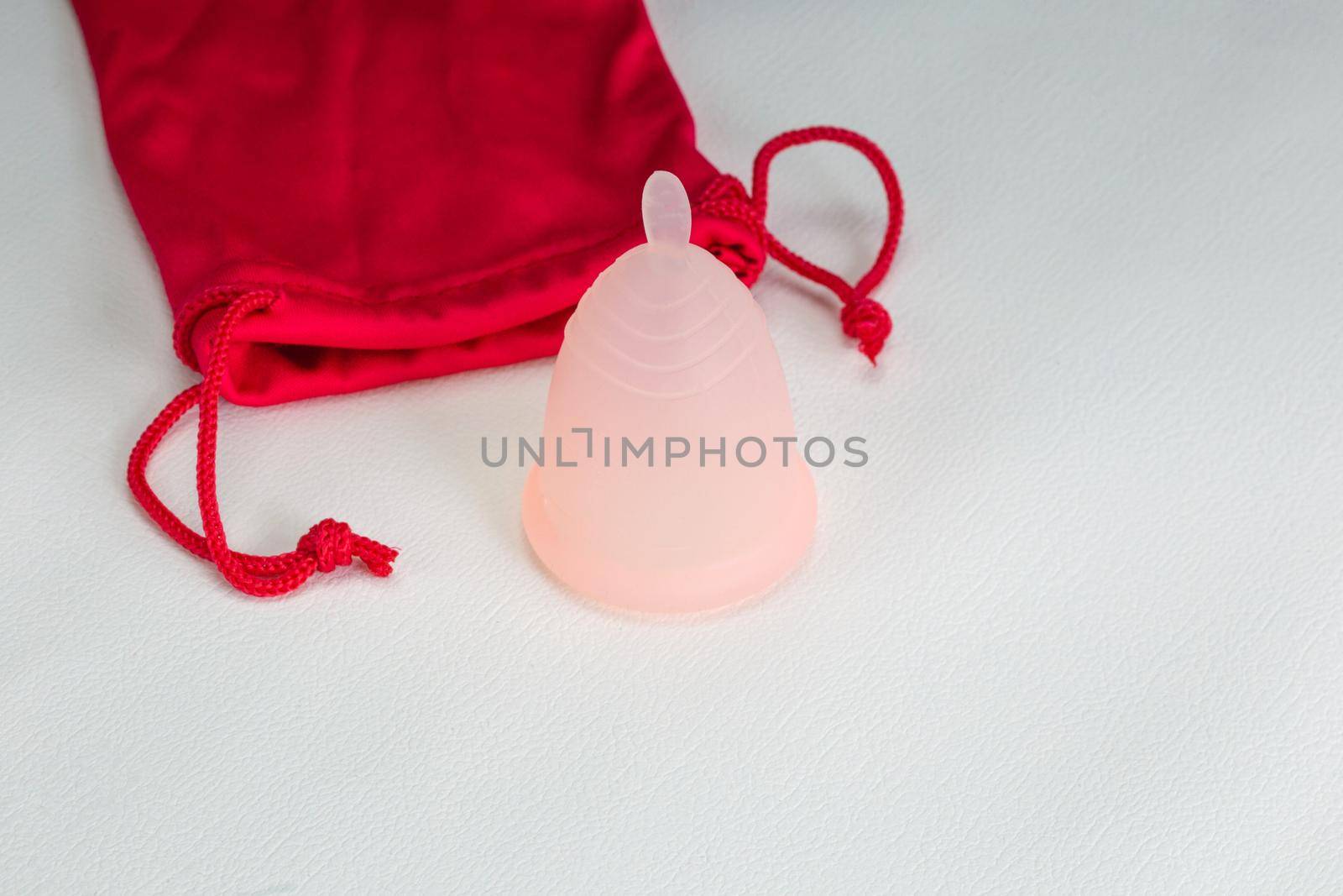 Menstrual cup on white background. Eco friendly alternative for Women period products with copy space and pink pounch