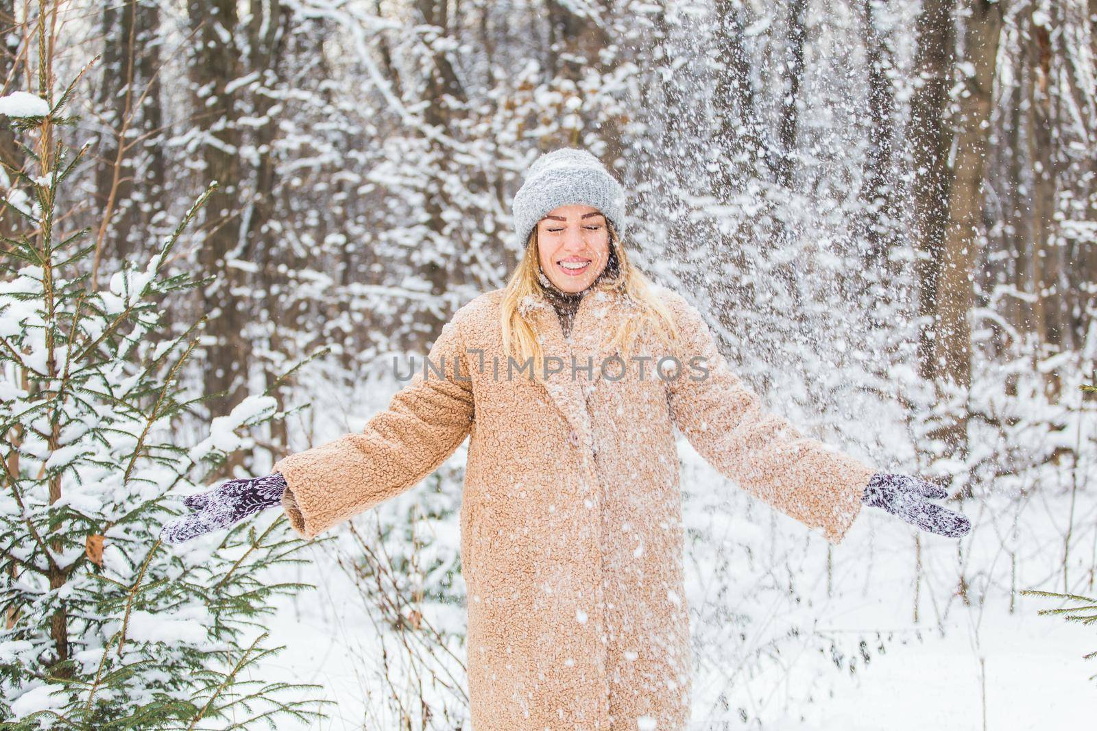 Woman throws up snow, fun and winter concept. by Satura86