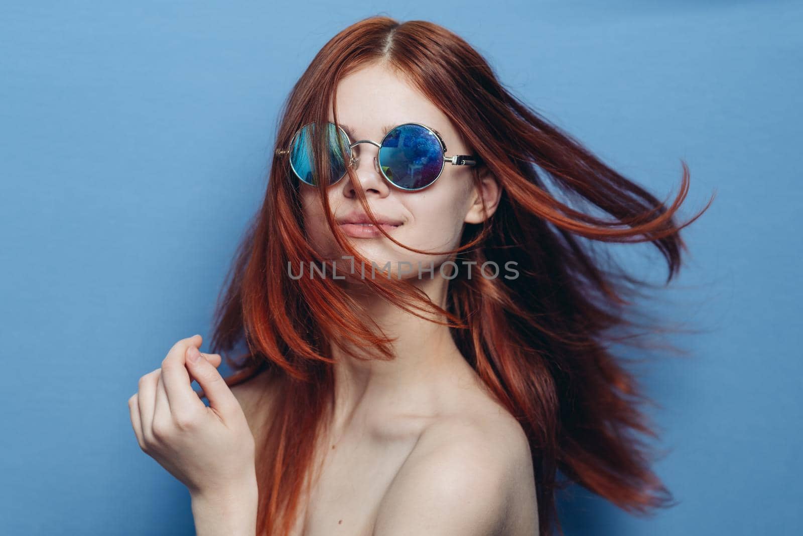 attractive woman with bare shoulders fashionable glasses blue background. High quality photo