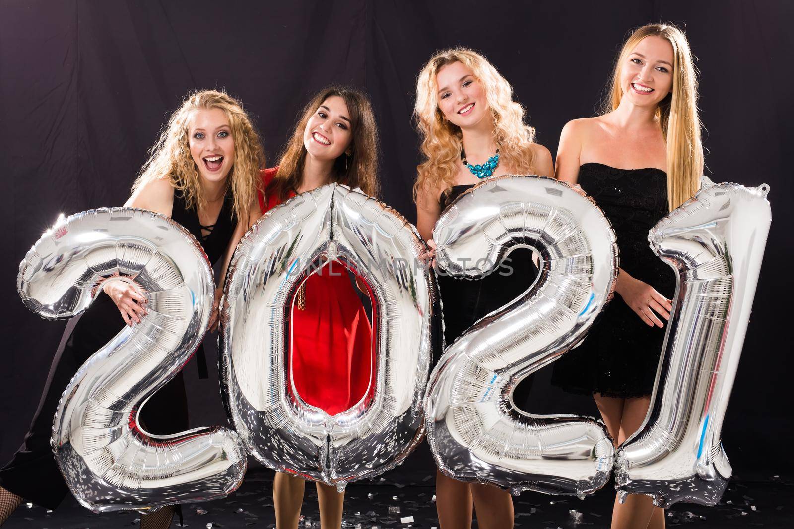 Party and new year holidays concept - cheerful young women celebrating new years eve 2021