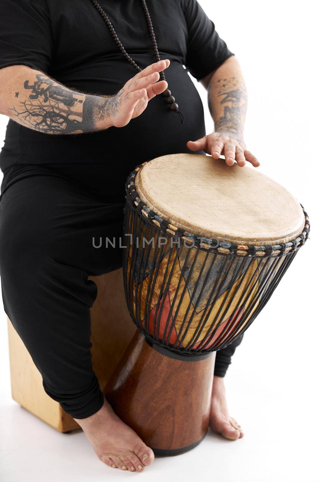 Funn caucasian bearded tattoed man is posing on white background