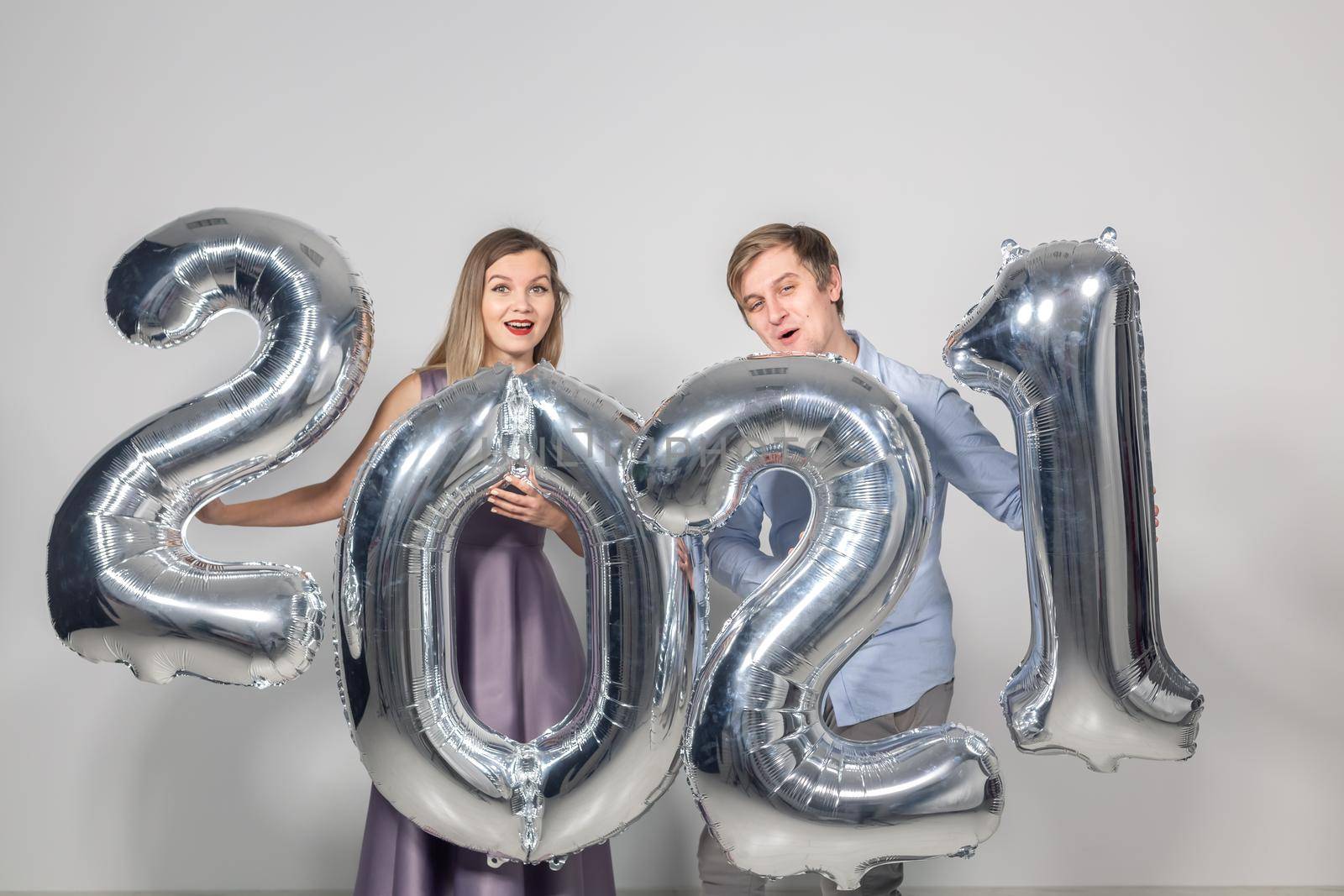 Party, people and new year holidays concept - woman and man celebrating new years eve 2021.