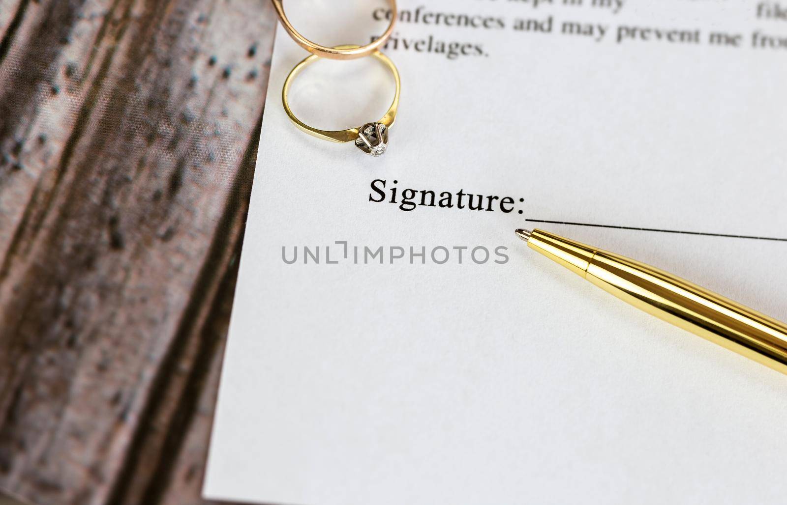 Marriage contract with two golden wedding rings and gold pen, prenuptial agreement, macro close up, sign with signanture,document,agreement concept by Annebel146
