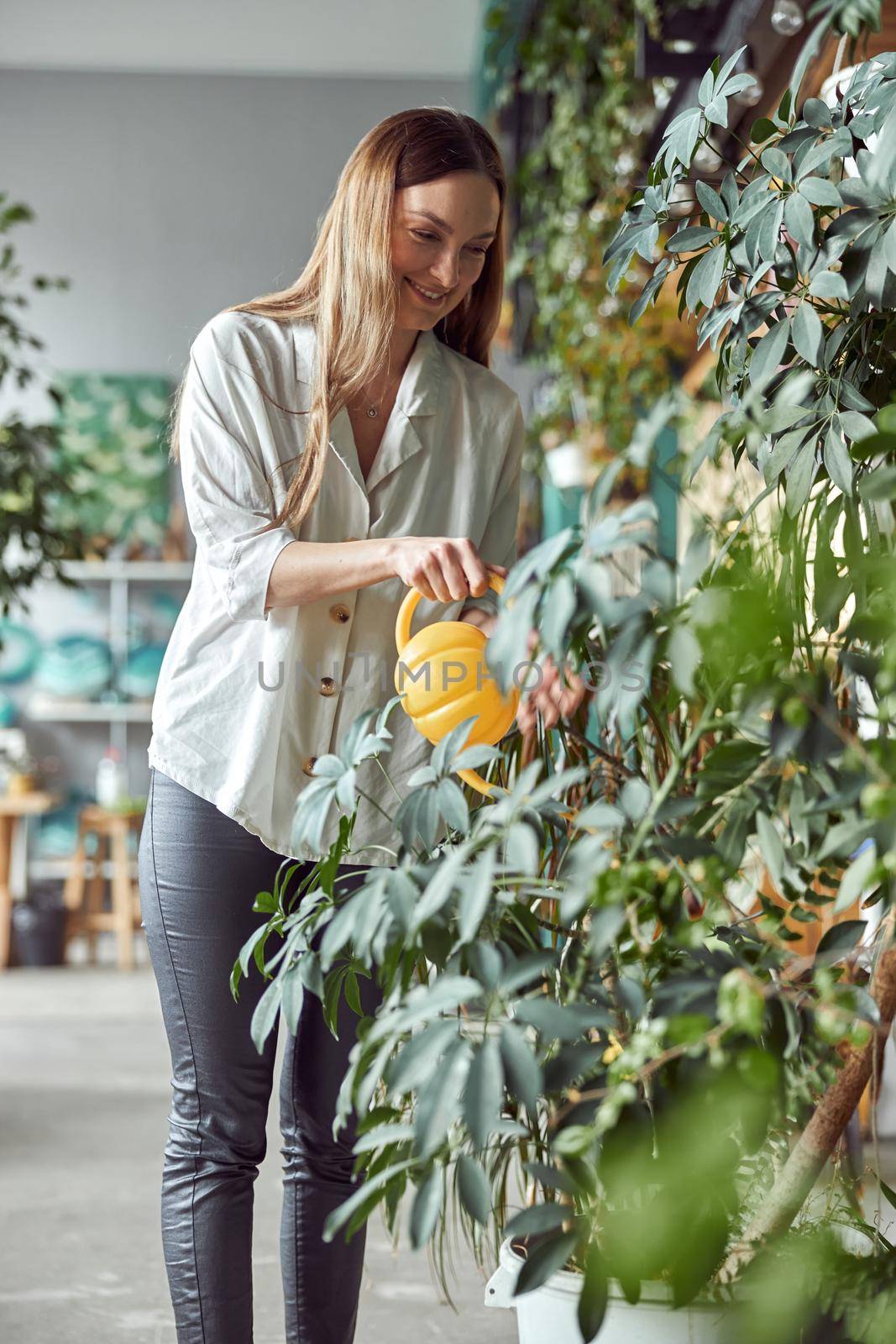 Confident female florist is working with dryed flowers in cozy flower shop