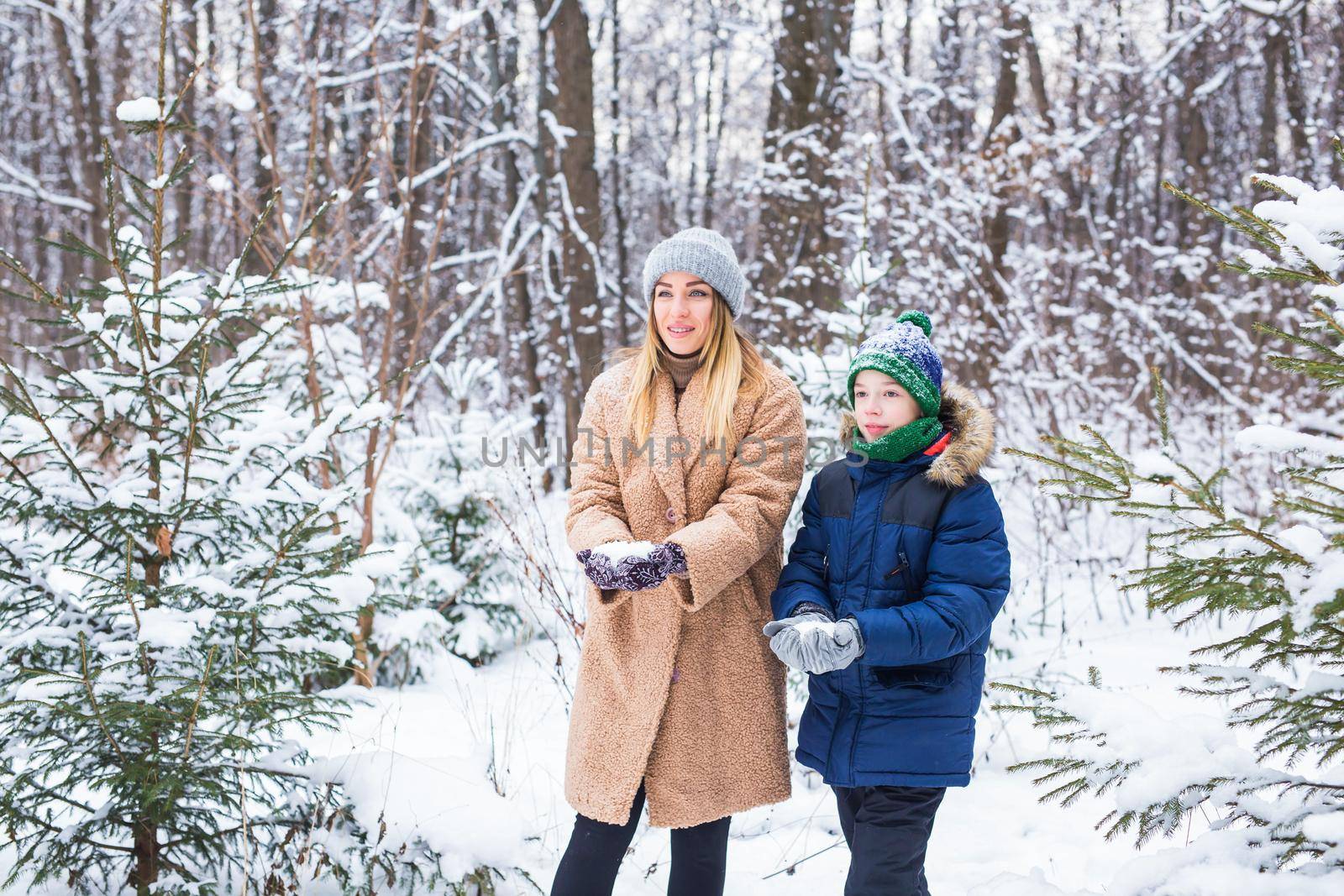 Portrait of happy mother with child son in winter outdoors. Single parent.