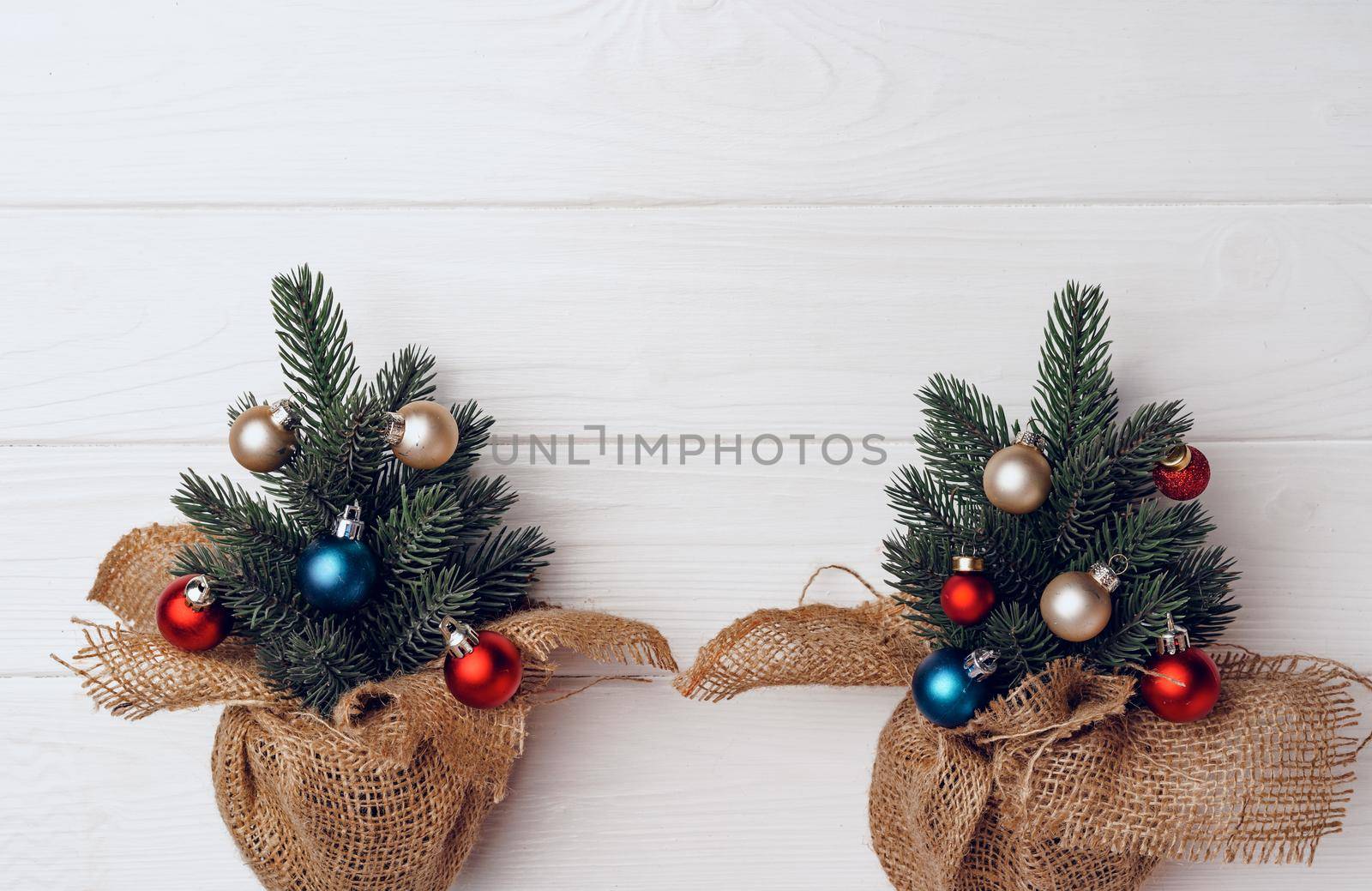 Christmas tree branches decorated with baubles on white background top view