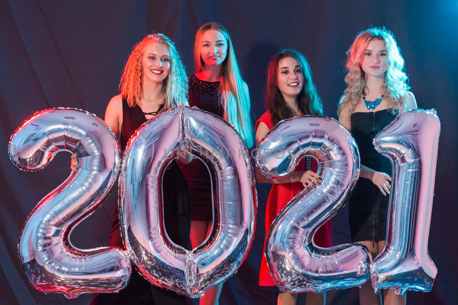 Party and new year holidays concept - cheerful young women celebrating new years eve 2021