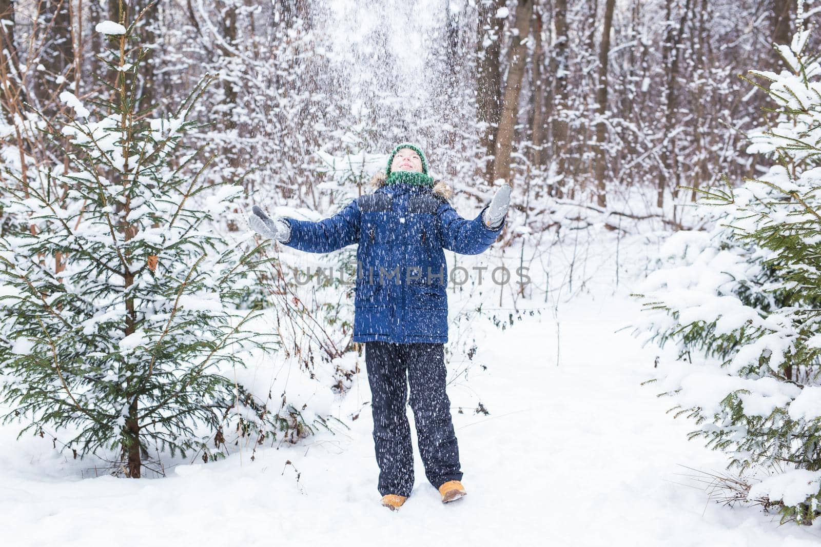 Happy boy throwing snow. Child, season and winter concept. by Satura86