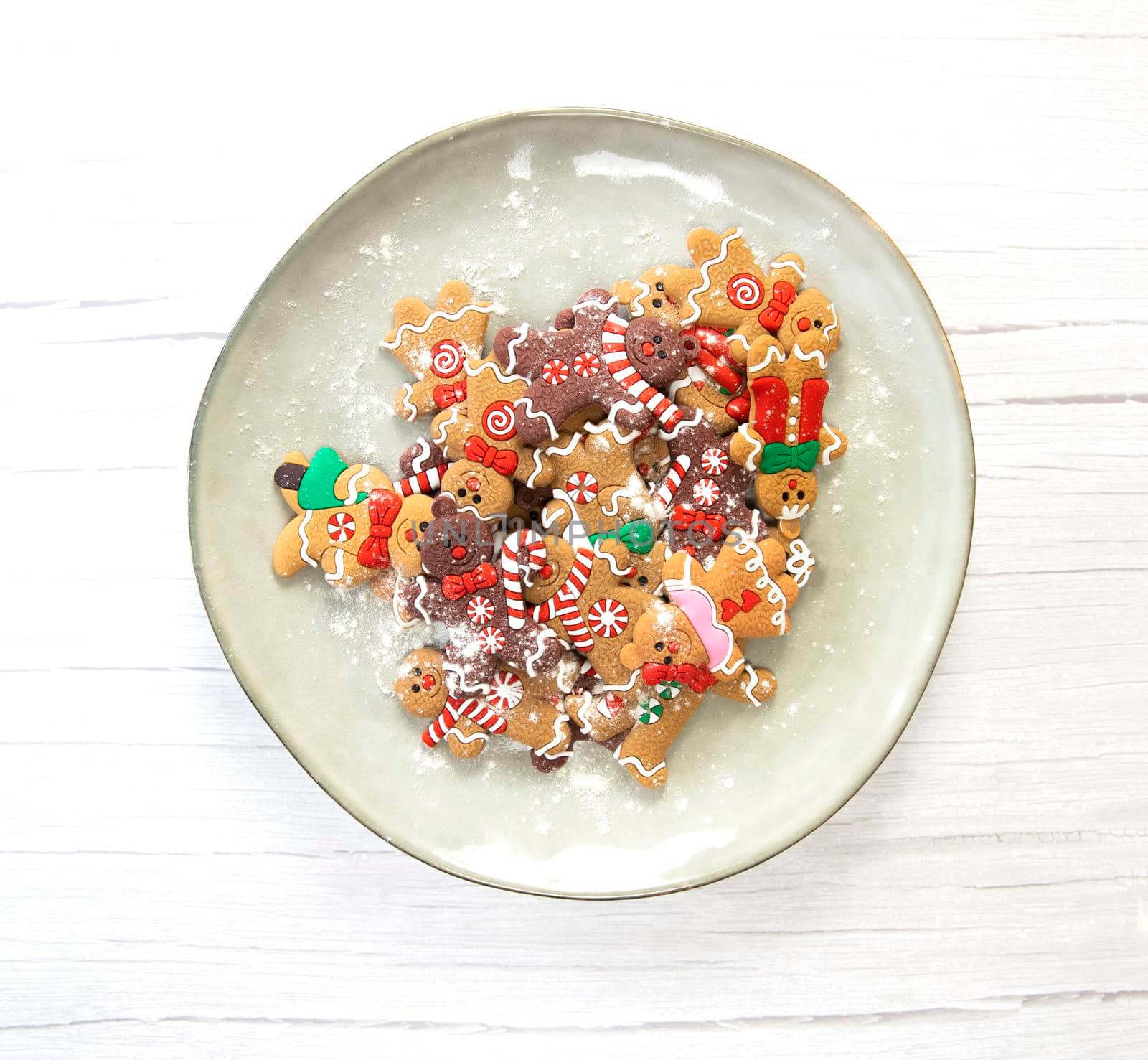 Christmas cookies,gingerbread man cookies with powdered sugar on natural plate, white wooden background texture,homemade top view copy space