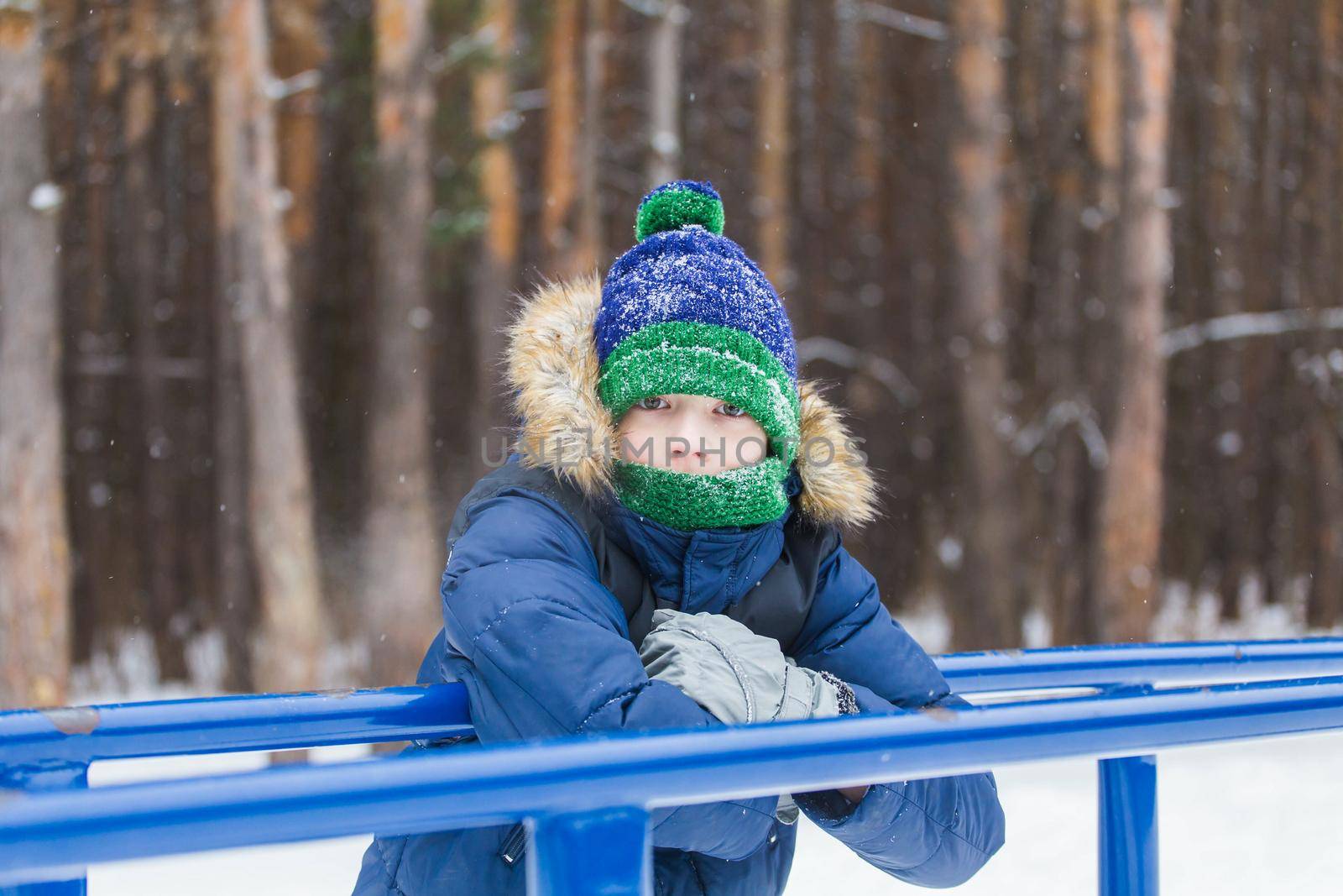 Cute young boy plays with snow, have fun, smiles. Teenager in winter park. Active lifestyle, winter activity, outdoor winter games, snowballs. by Satura86