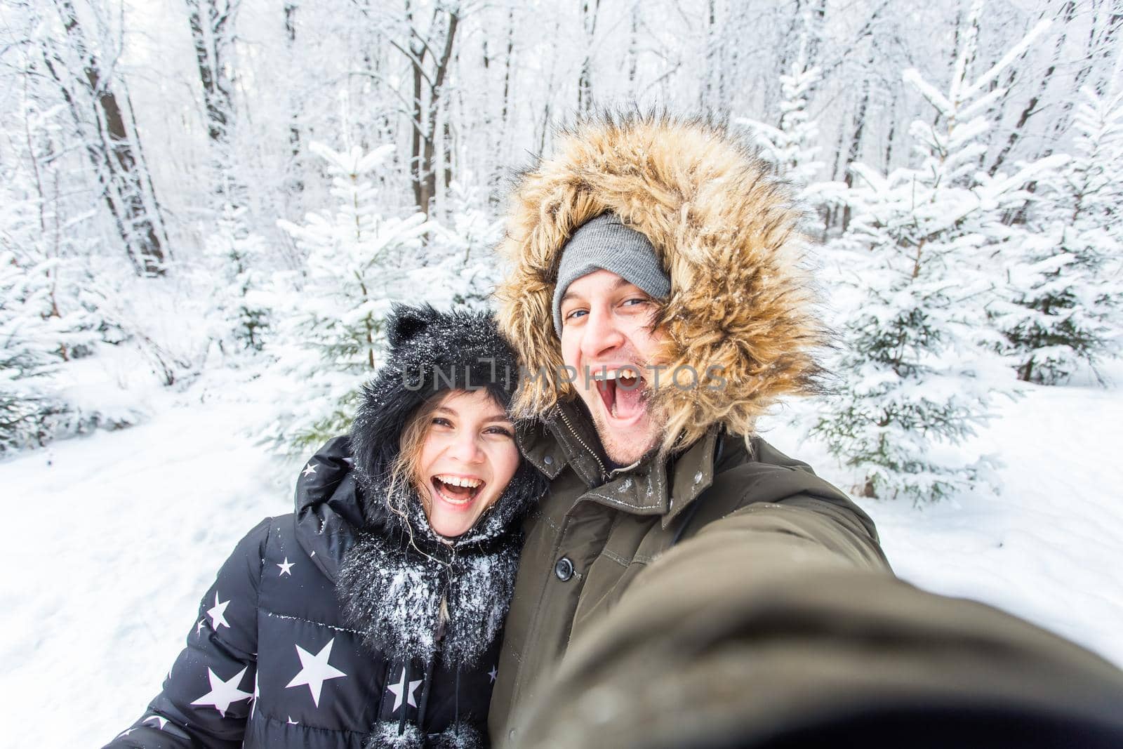 Season, love, technology and leisure concept - happy couple taking selfie by smartphone over winter background by Satura86