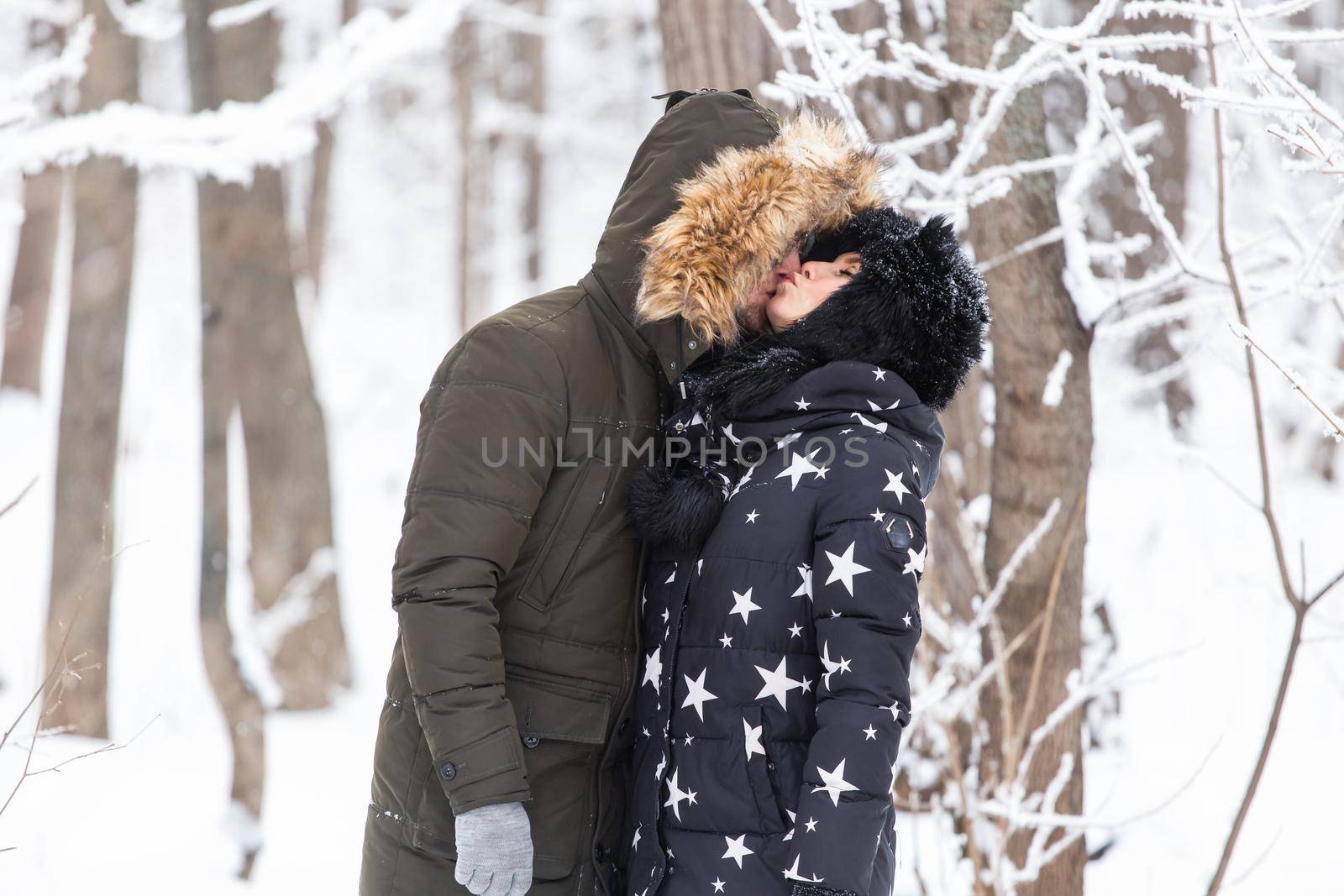 Young love couple kissing in a snowy park. Winter season. by Satura86