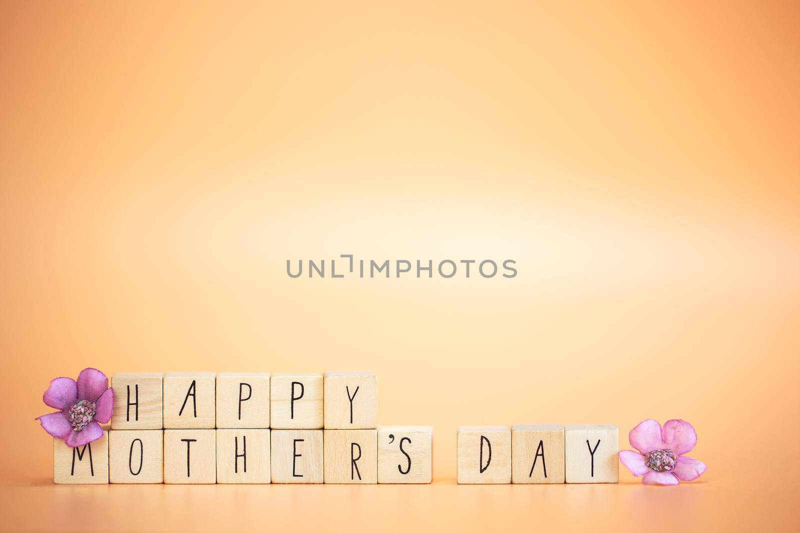 Happy Mother's Day Card. Text Happy mothers Day on bright pastel orange colored background with colorful purple flowers, modern retro design with copy space, Mother,Spring,Greeting card,Holiday concept space for text