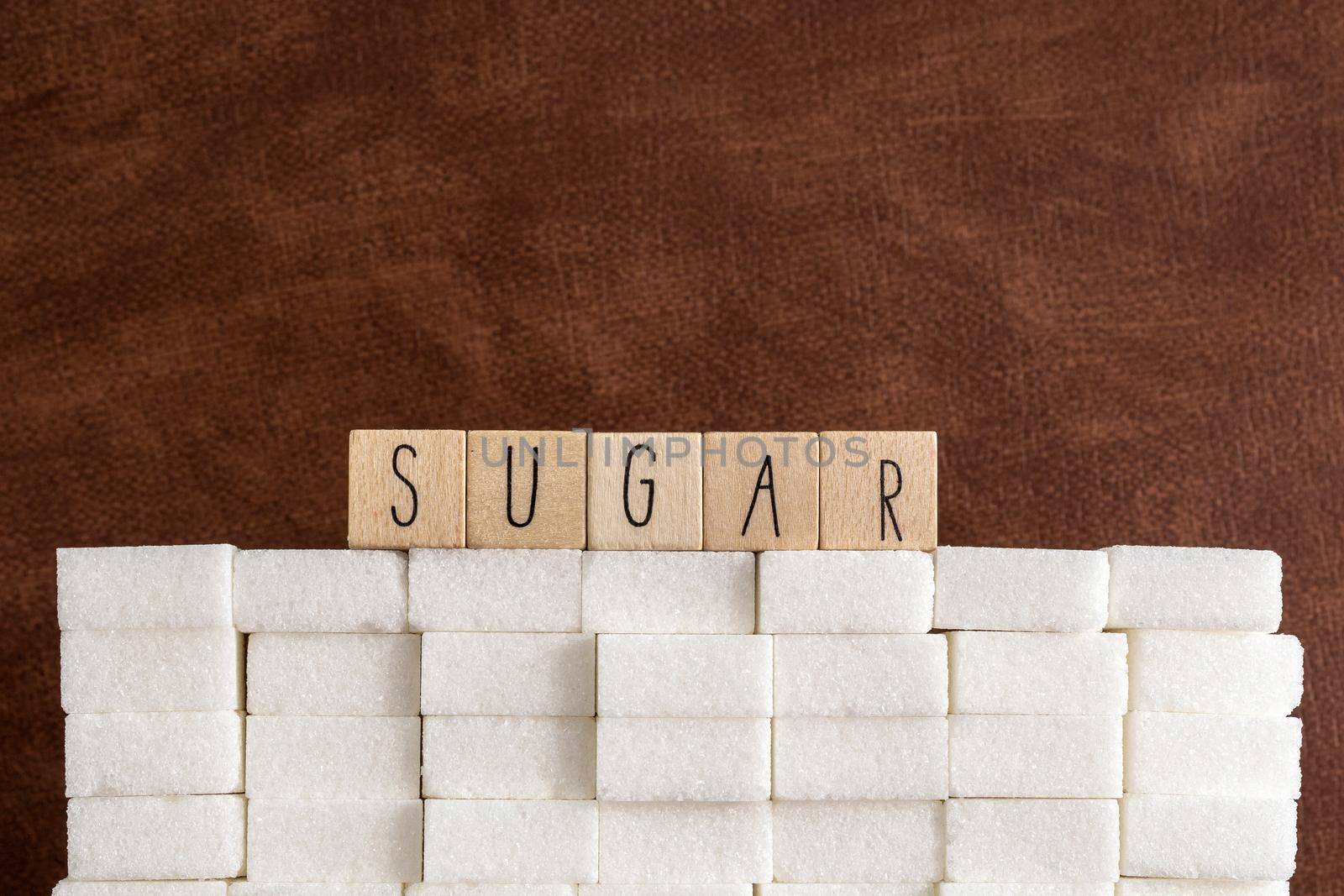 Sugar cubes wall with the text Sugar on brown natural background texture, Health,diabetes,medical,sugar,sweet.junk food concept copy space