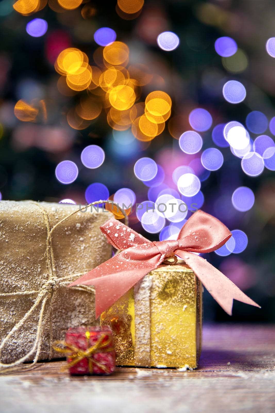 Merry Christmas, New Year, gifts in gold boxes with pink bow in the snow, bokeh Christmas tree background with copy space, Holiday,present concept space for text