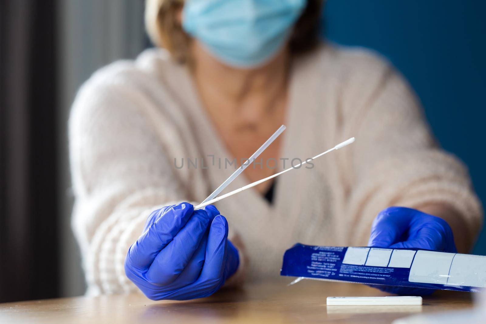 Senior woman studying and taking the self test for Covid-19, home test kit for coronavirus close-up