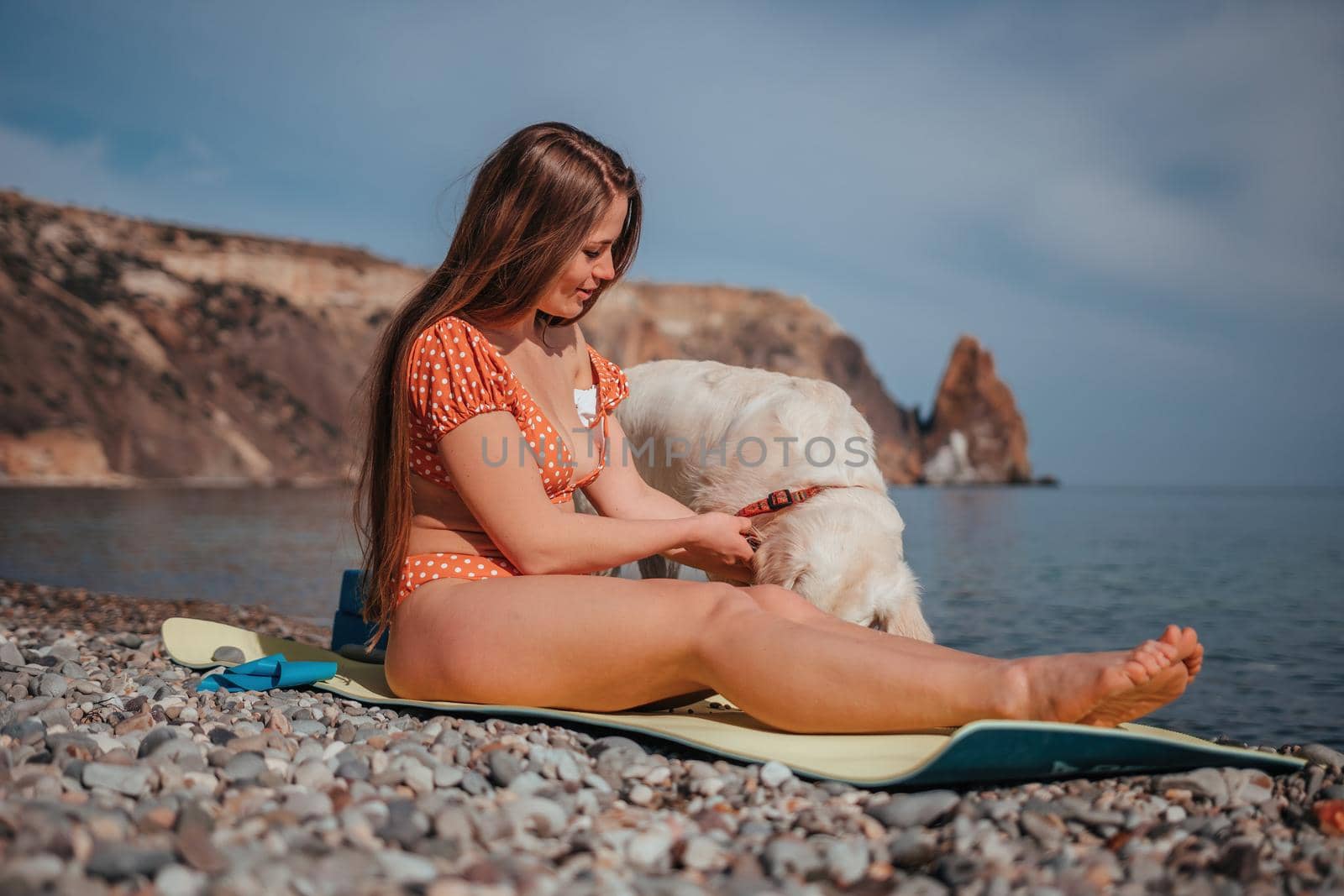 Young woman in swimsuit with long hair practicing stretching outdoors on yoga mat by the sea on a sunny day. Women's yoga fitness pilates routine. Healthy lifestyle, harmony and meditation concept by panophotograph