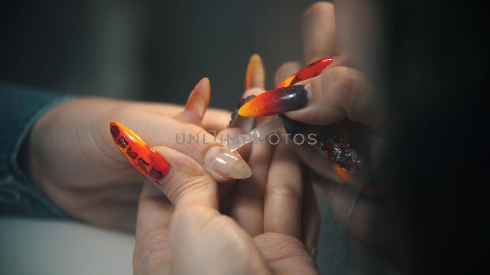 Doing manicure - applying base on the nail. Mid shot