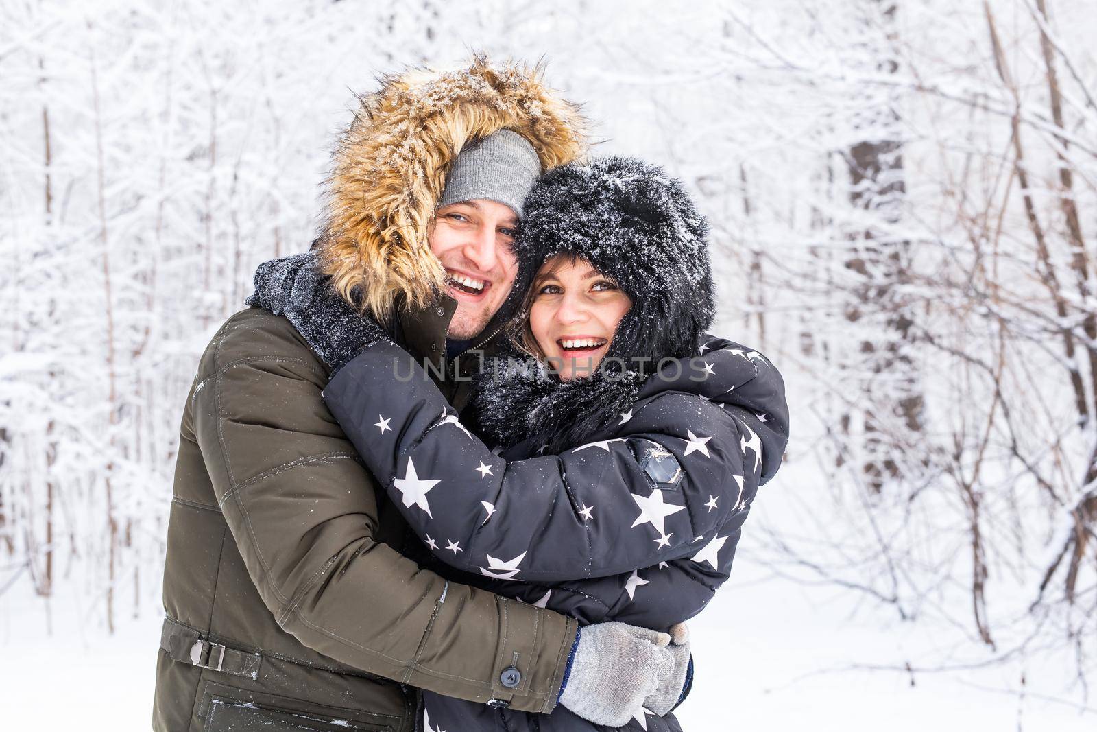 Young couple in love have fun in the snowy forest. Active winter holidays. by Satura86